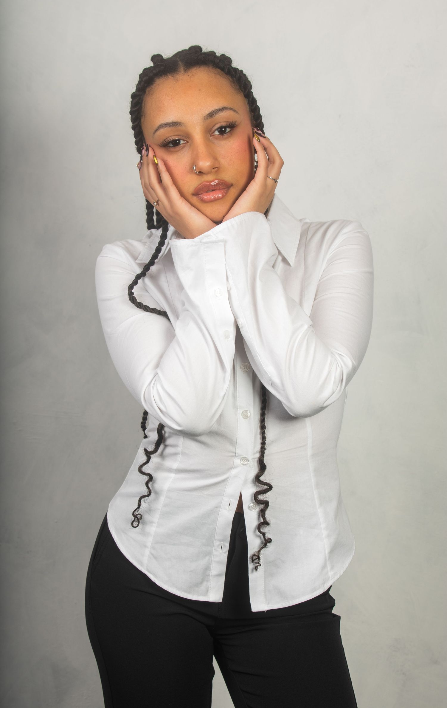 Fashion portrait series in classic white button-down shirt against light studio backdrop.