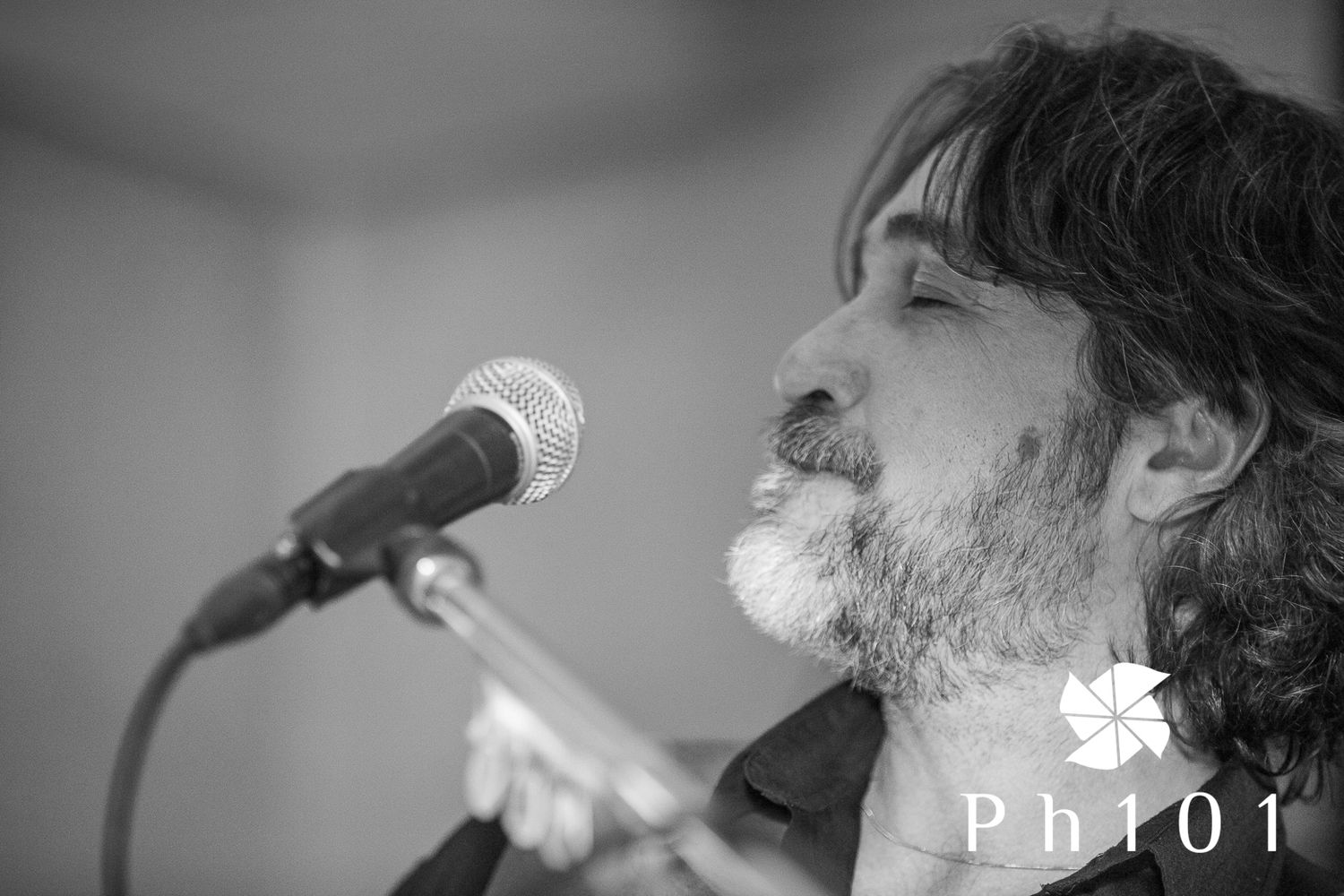 Black and white close-up profile shot of a performer with a microphone.