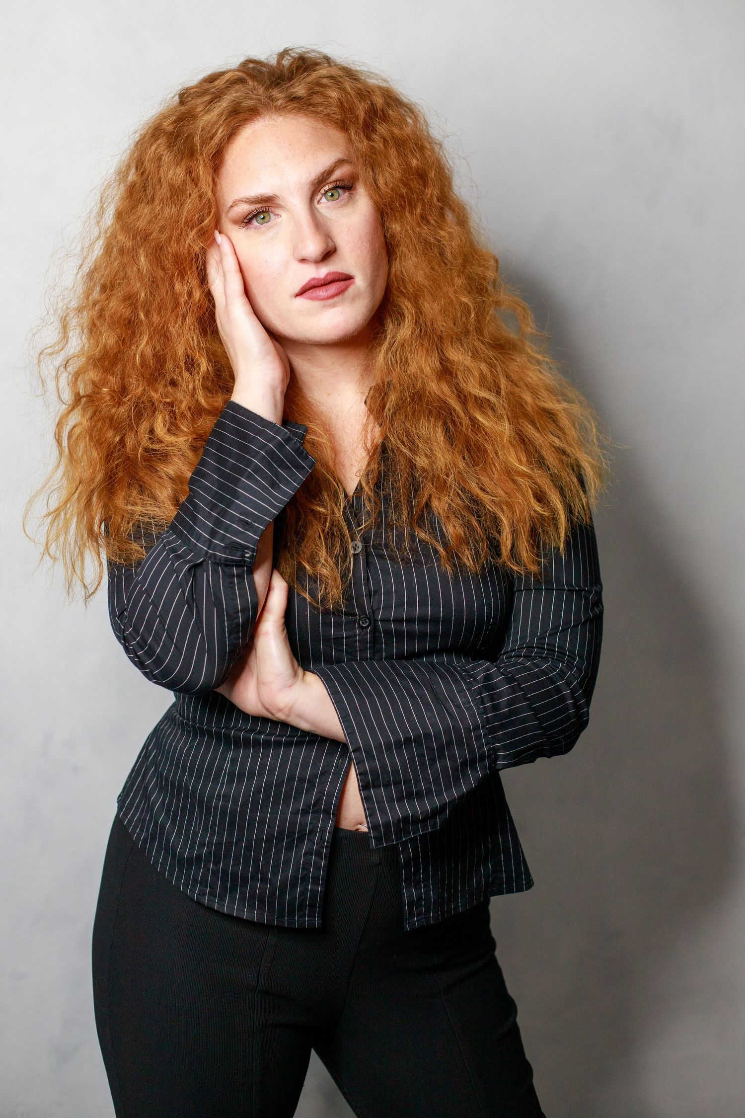 Fashion portrait series in pinstripe jacket against gray studio backdrop.