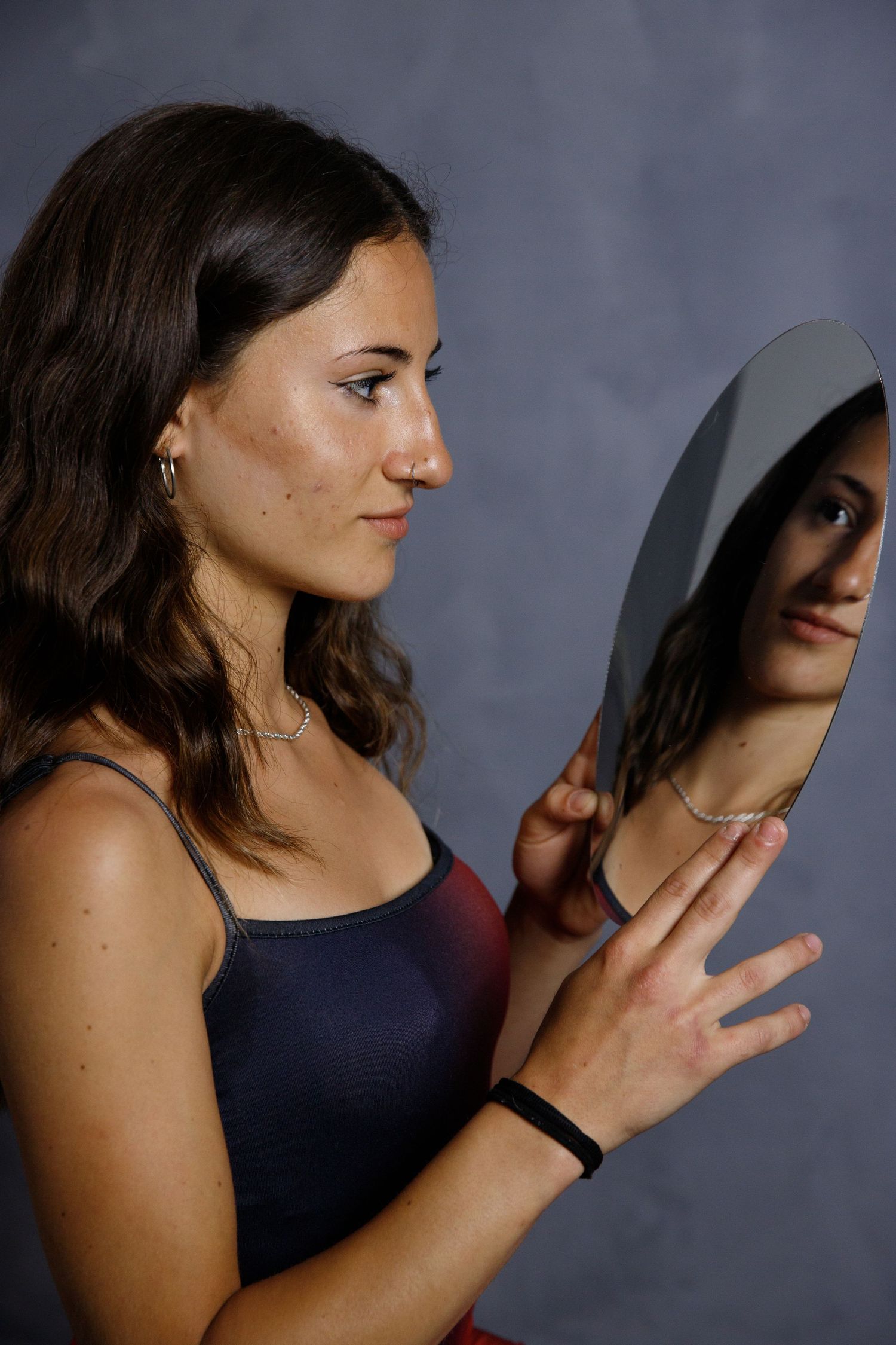 A series of dramatic profile portraits showing someone in a dark top against a moody background.