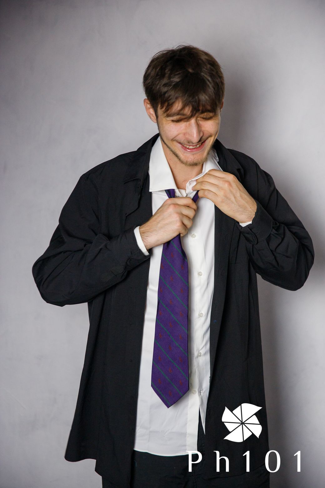 Professional photoshoot showing emotions and gestures in business attire with purple tie.