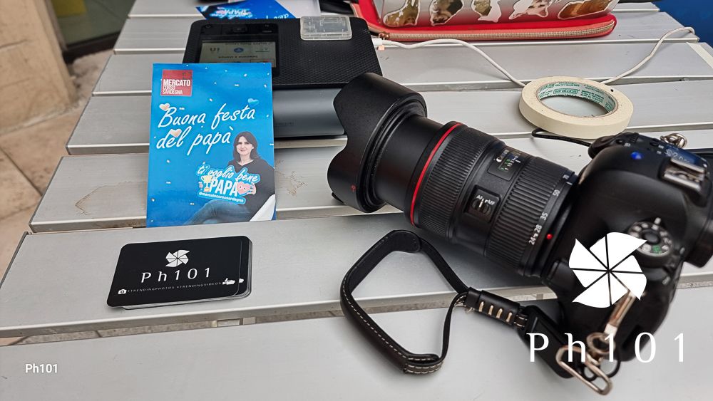 A collection of camera equipment and accessories laid out on a wooden surface with blue and red items visible.