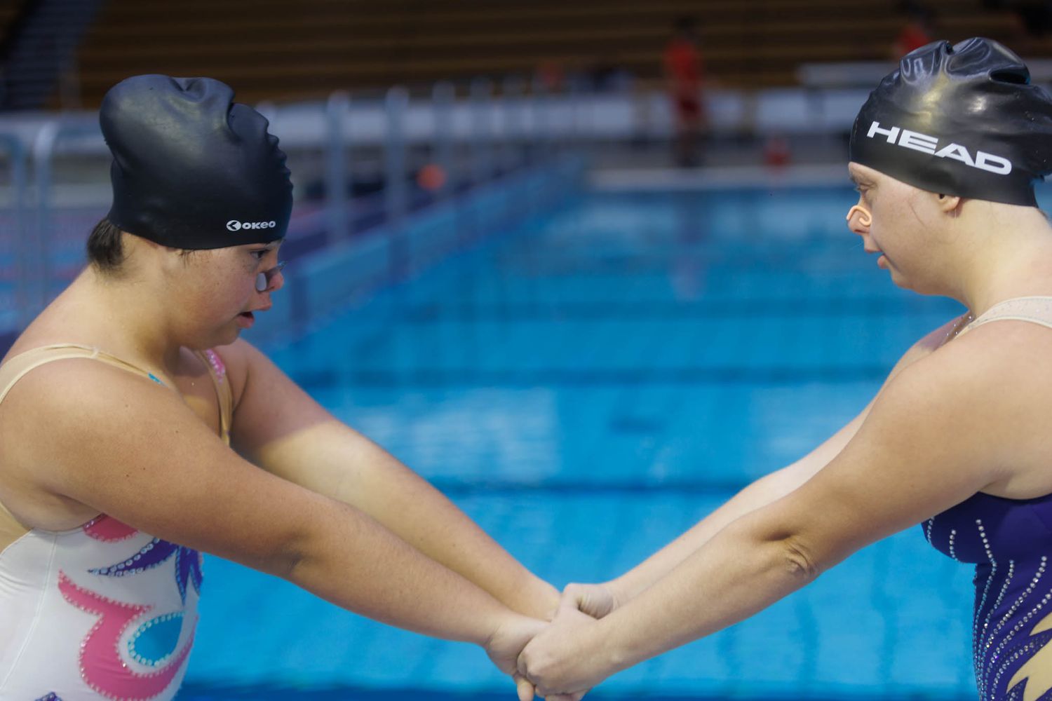 Swimmers passing relay batons in a competitive pool race.