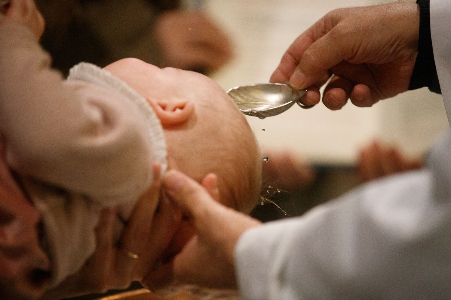 Close-up of hands during a baptism ceremony.