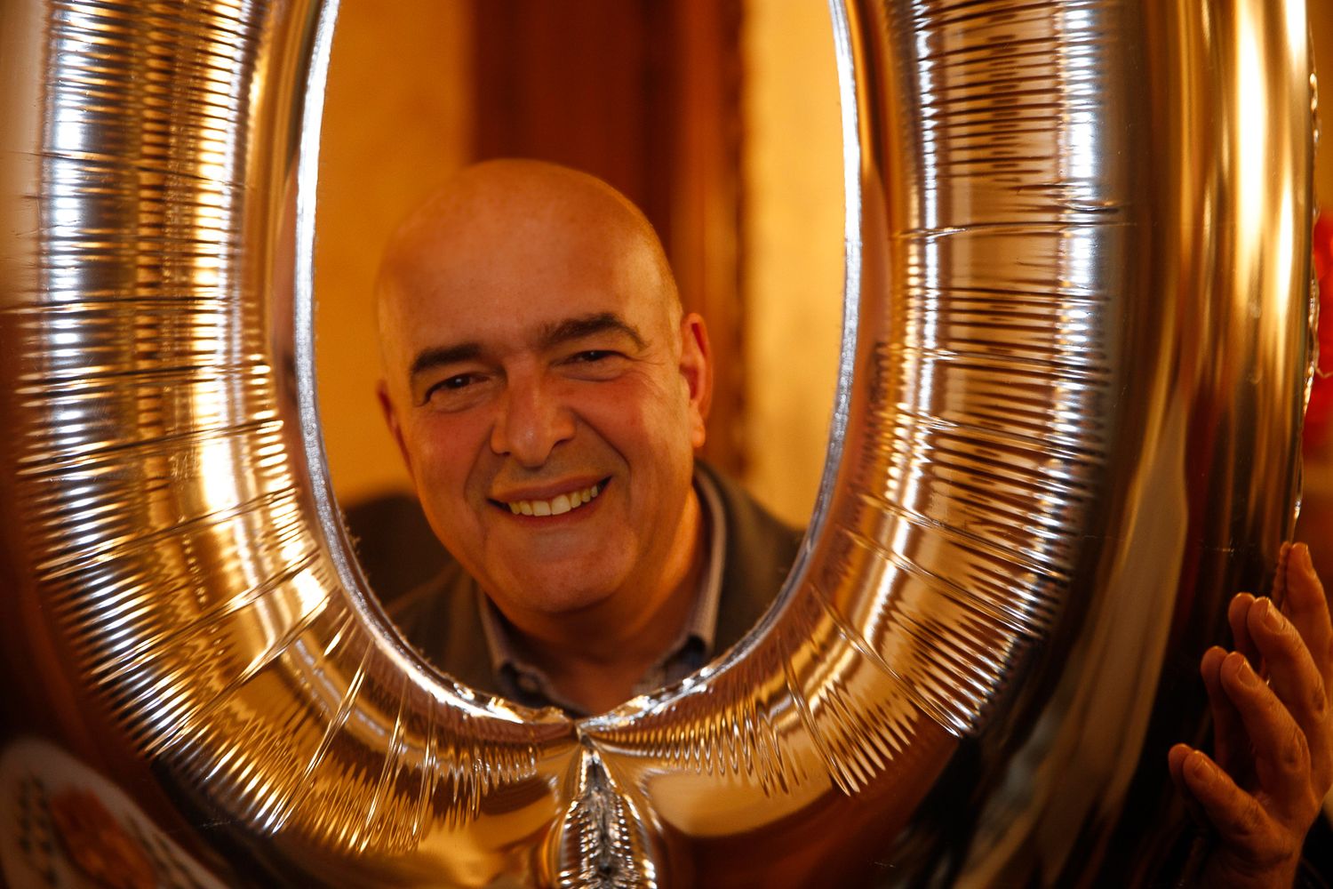 Close-up of metallic silver number balloon decorations in warm lighting.