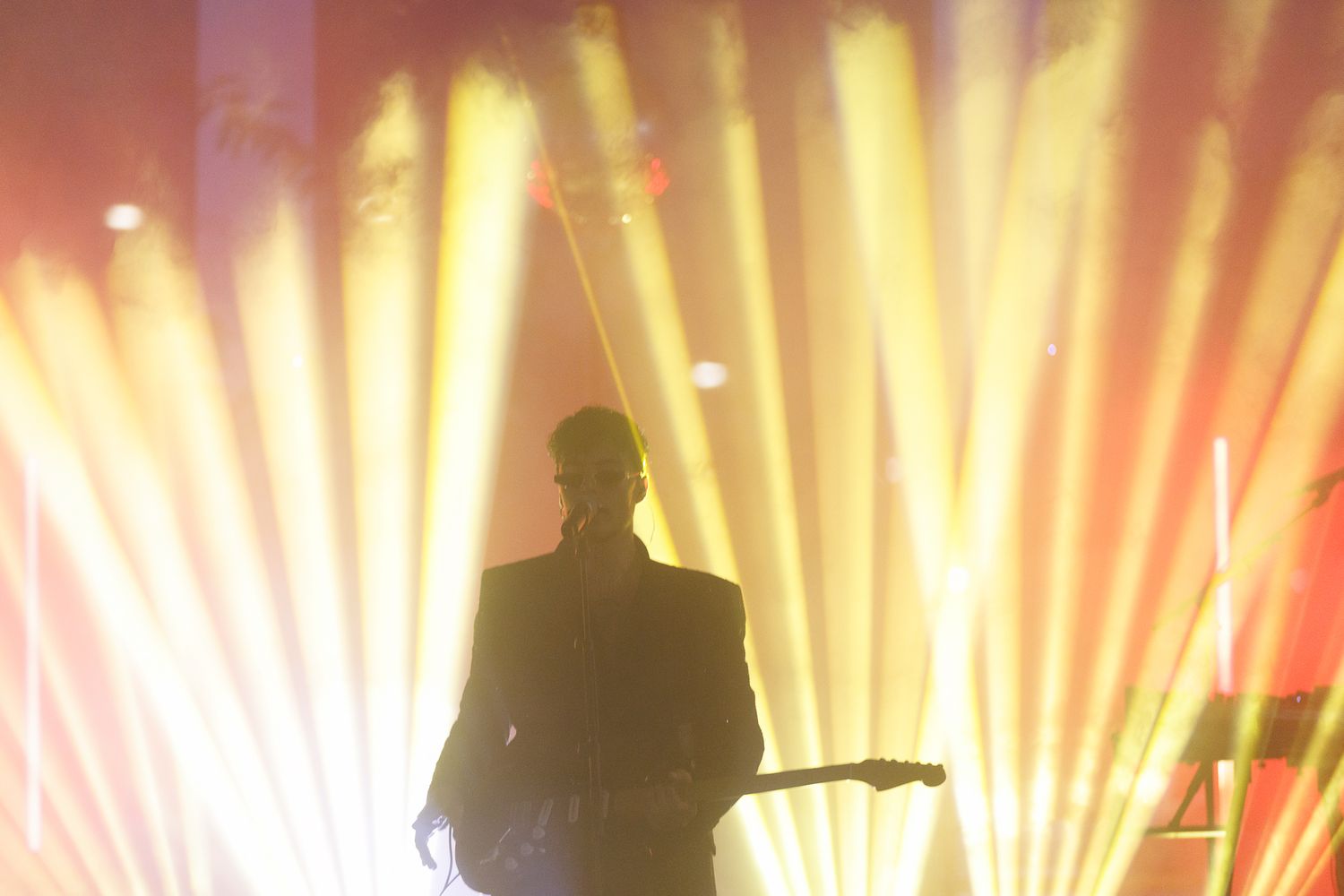 Golden stage lights create dramatic silhouettes during an evening performance.