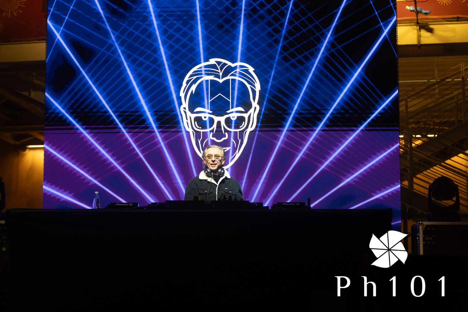 Stage light show with blue laser beams creating geometric patterns.