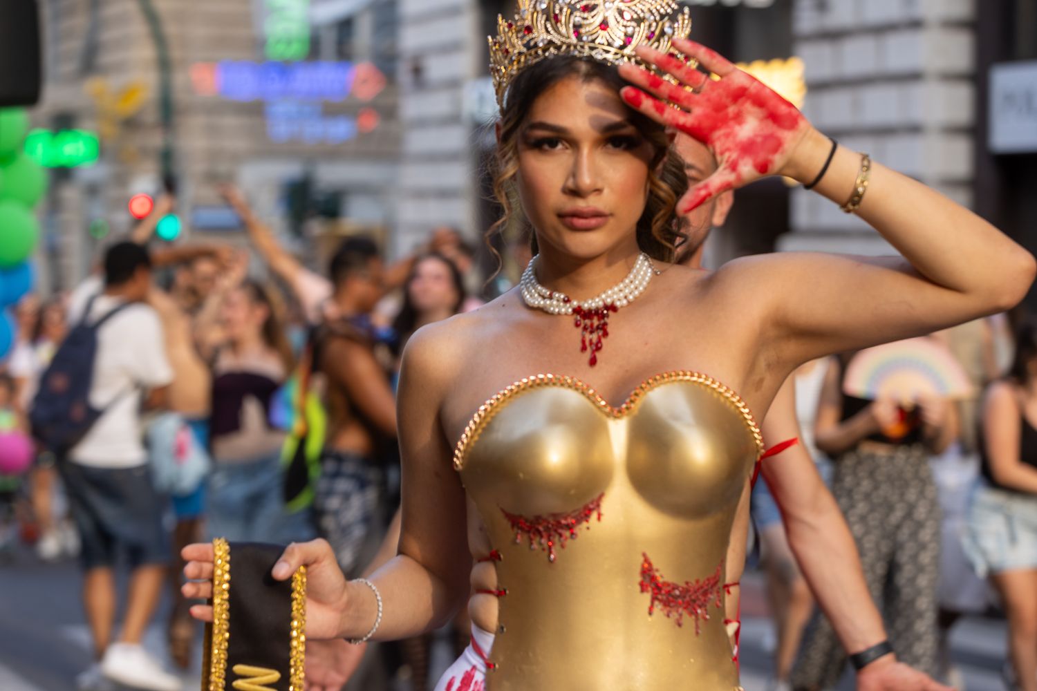 Pride parade participants in festive gold costumes and accessories.