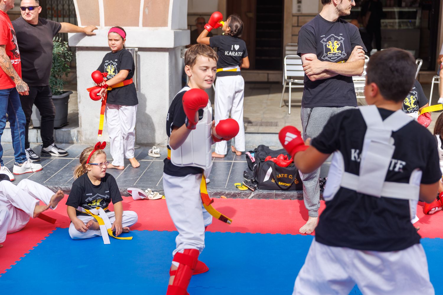 Sports activity session with red and blue mats set up outdoors.