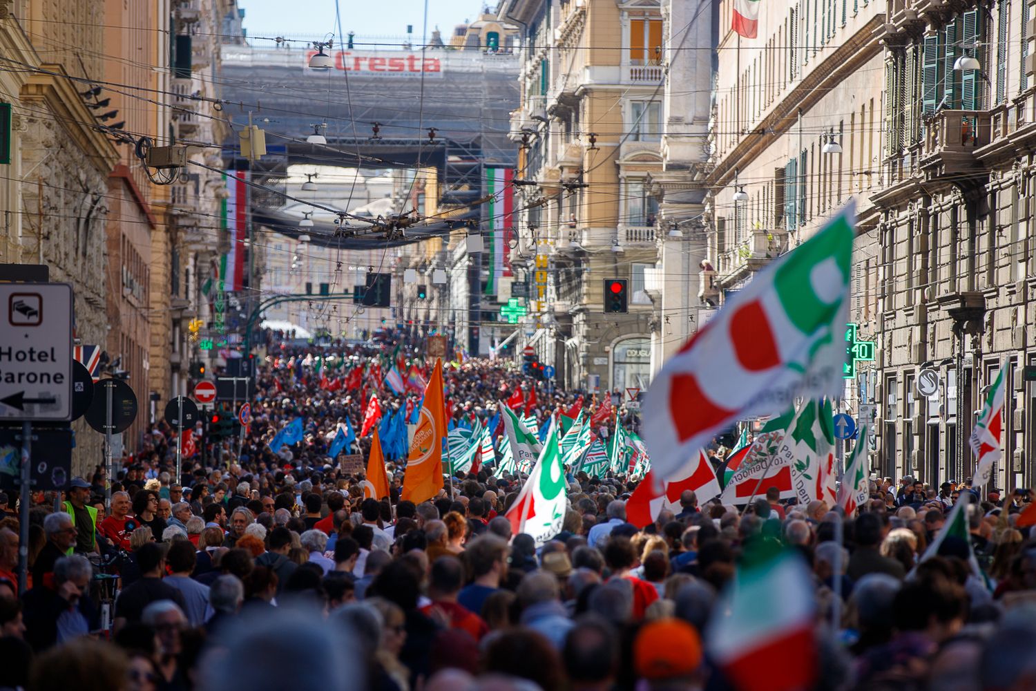 Crowded Italian street filled with national flags and celebrating people.