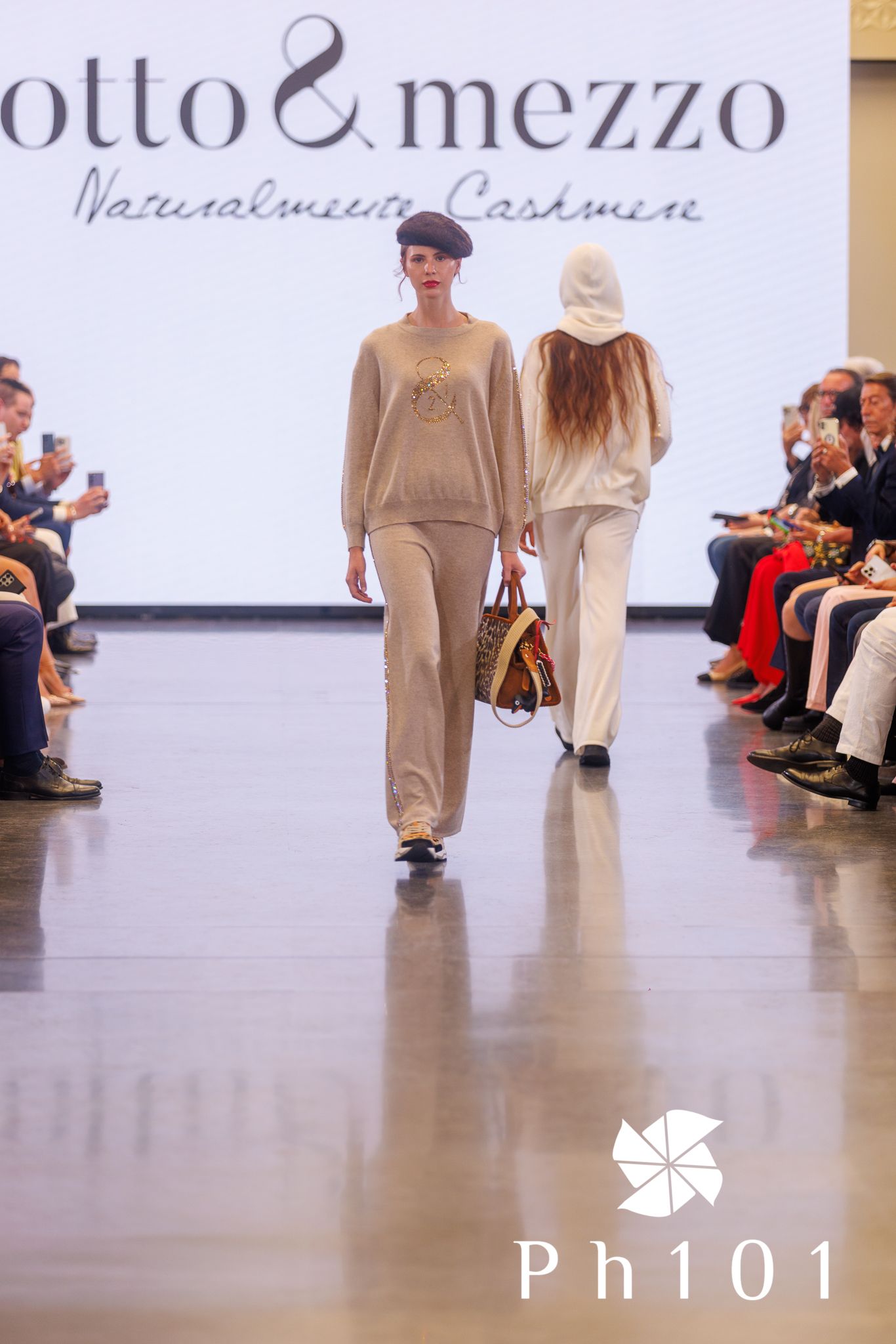 Models showcase flowing beige ensembles on runway for Otto & Mezzo collection.
