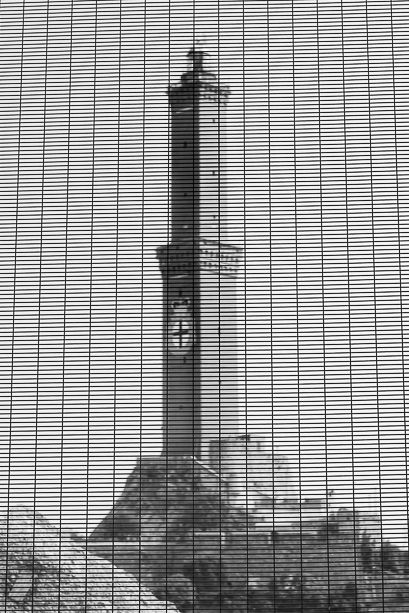 Industrial tower silhouette viewed through window blinds creating a linear pattern effect.