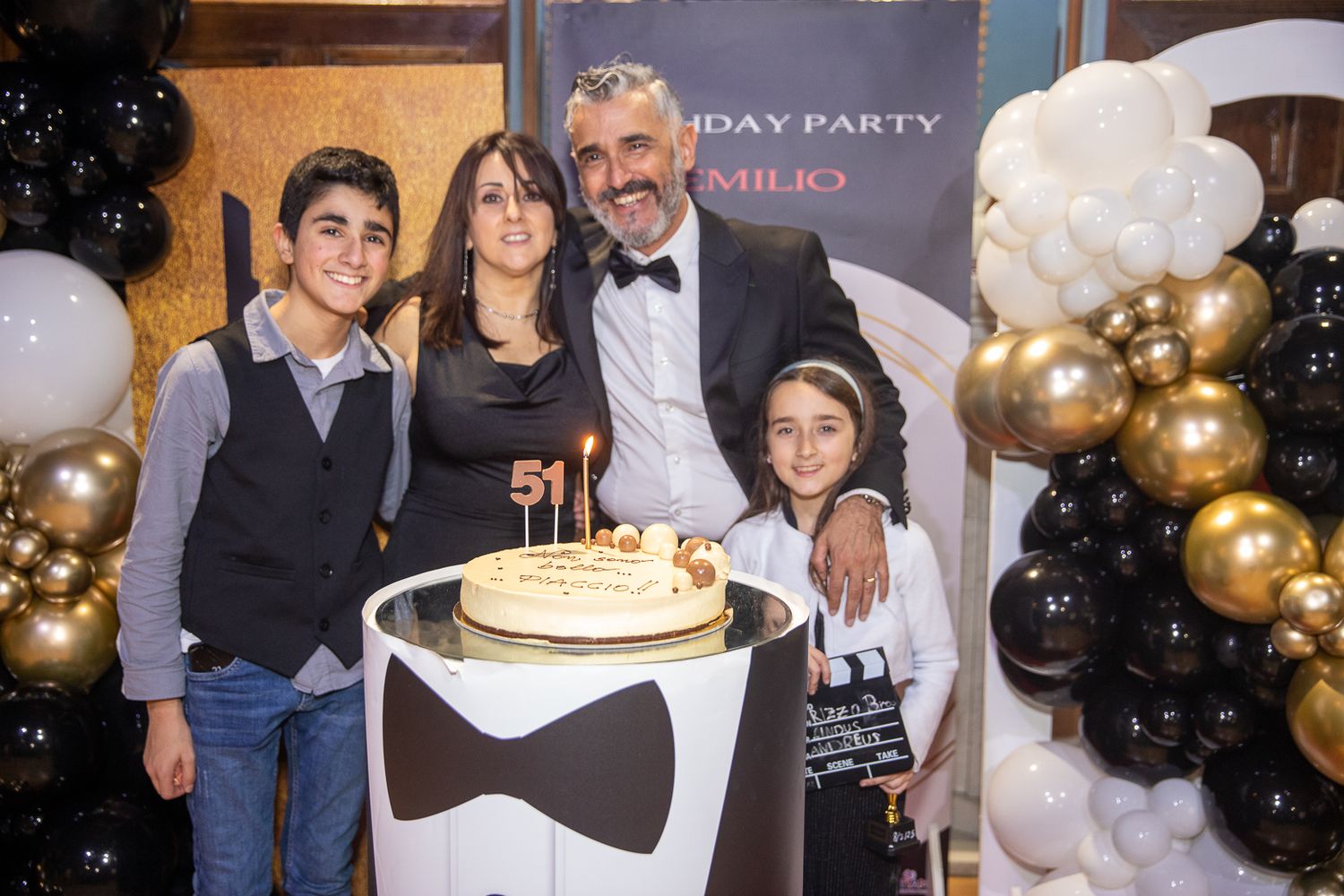 Birthday celebration with gold and black balloons and party decorations.