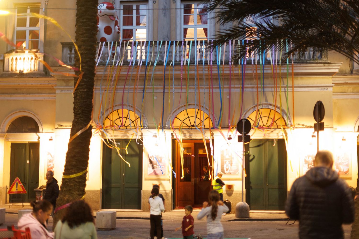 Illuminated exterior of a historic building with arched windows at night.
