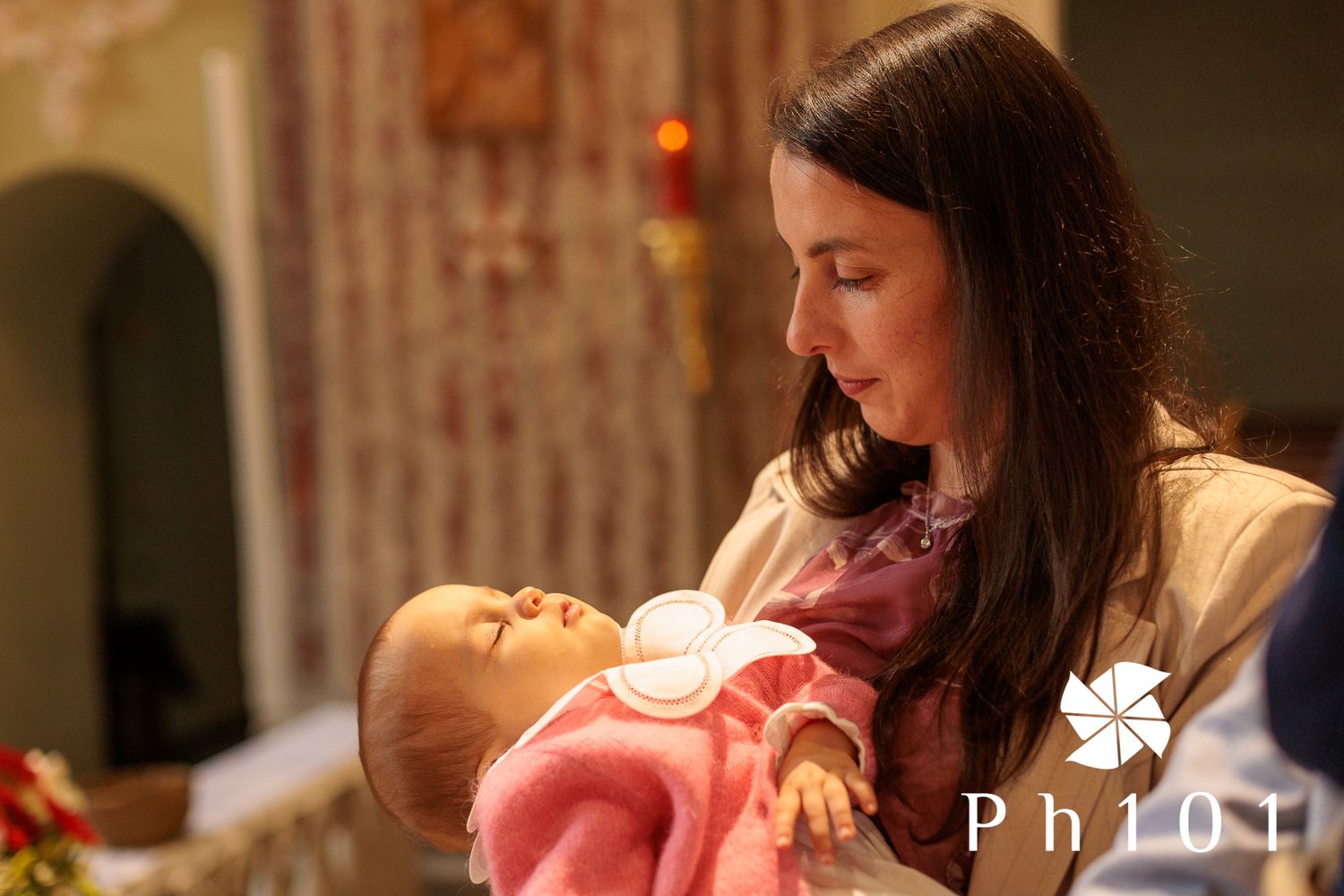 Intimate moment captured as parent holds baby in warm lighting during evening hours.