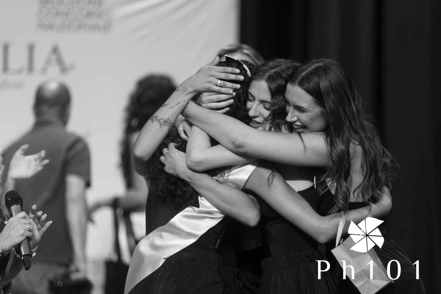 Group dance performance on stage with dramatic black and white lighting effects.