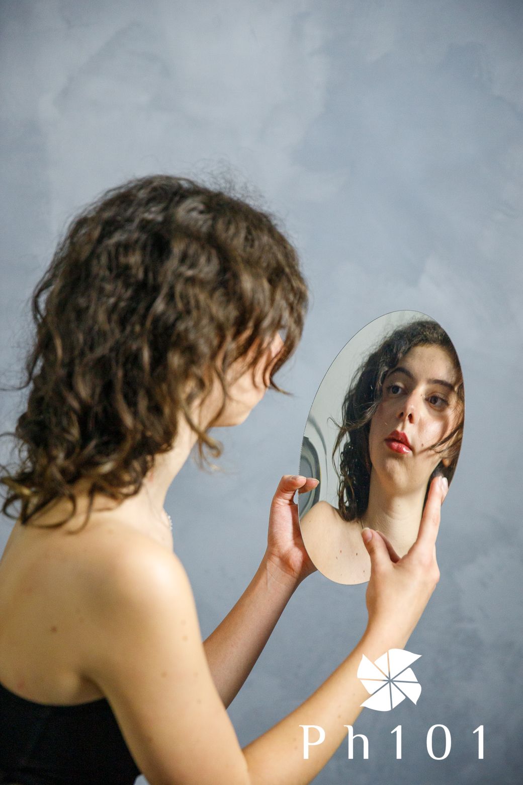 Artistic sequence showing person with curly hair listening to headphones against grey background.