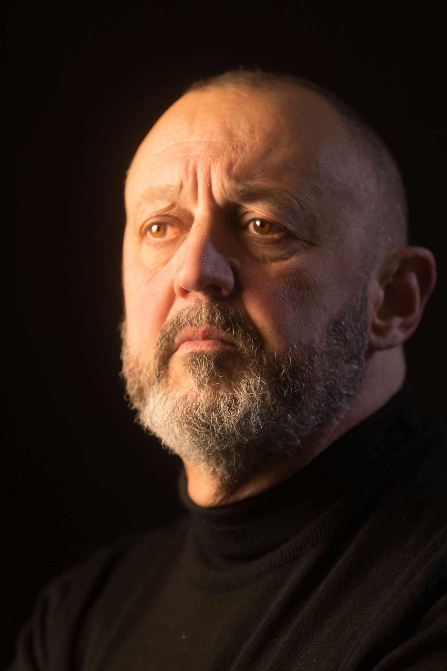 Dramatic black and white portrait series showing a bearded man in shadows looking to the side.