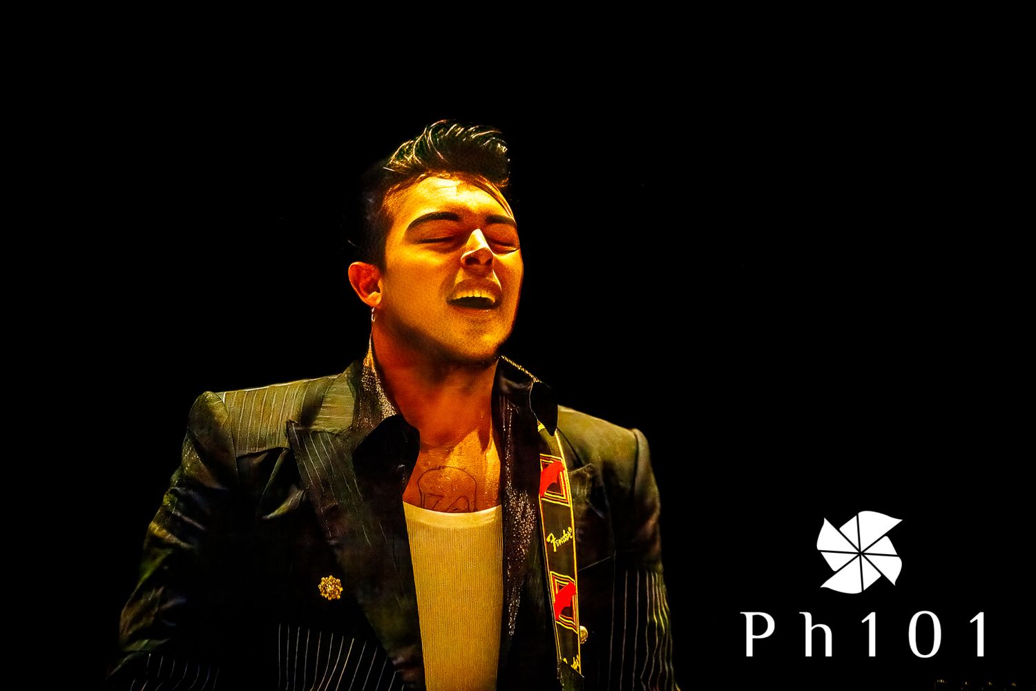 Live music performance on dimly lit stage with dramatic spotlighting.
