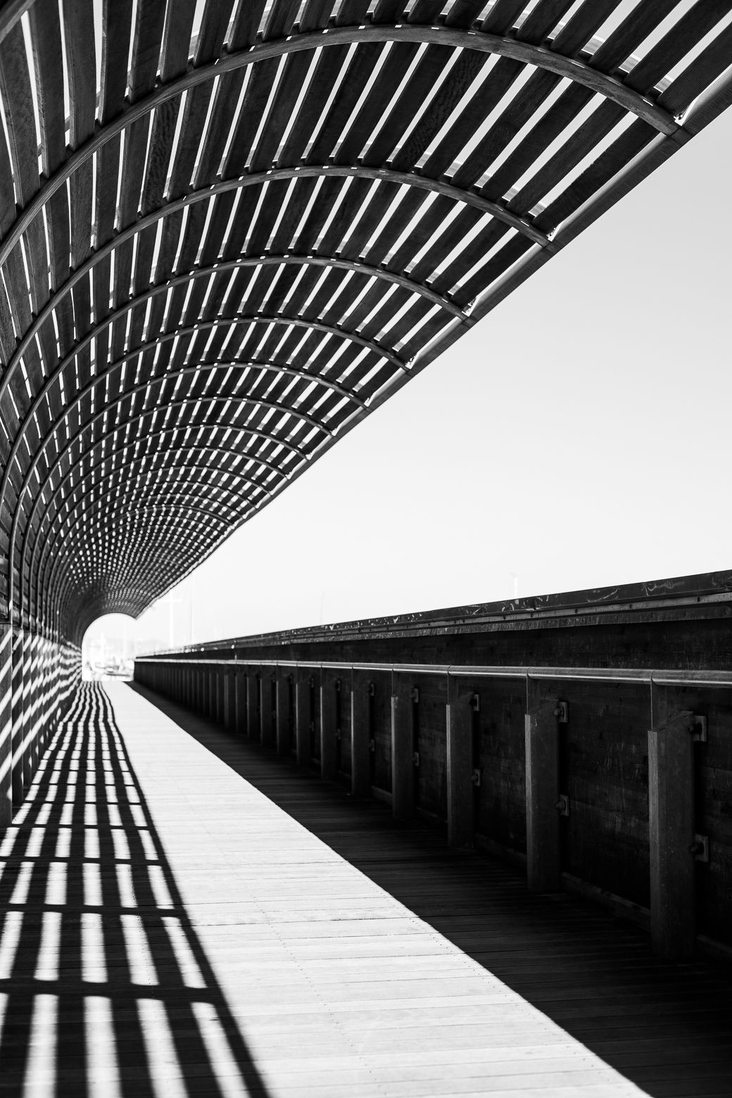 Black and white architectural corridor with striking geometric patterns creating a vanishing point perspective.