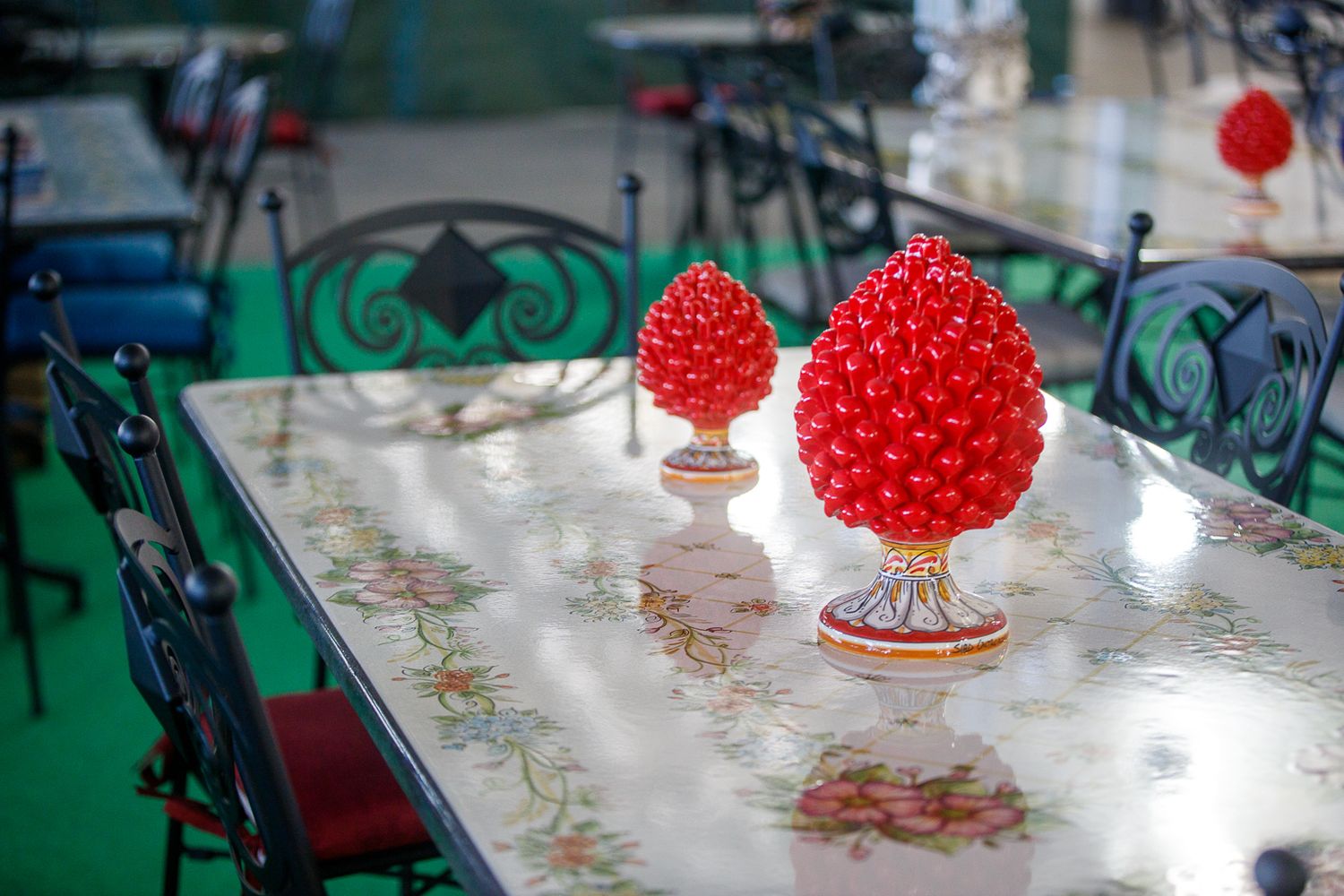 Red decorative ornaments displayed on reflective glass table surface.
