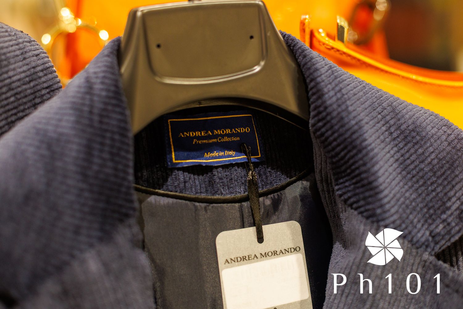 Close-up of clothing tags and labels on dark fabric in retail display.