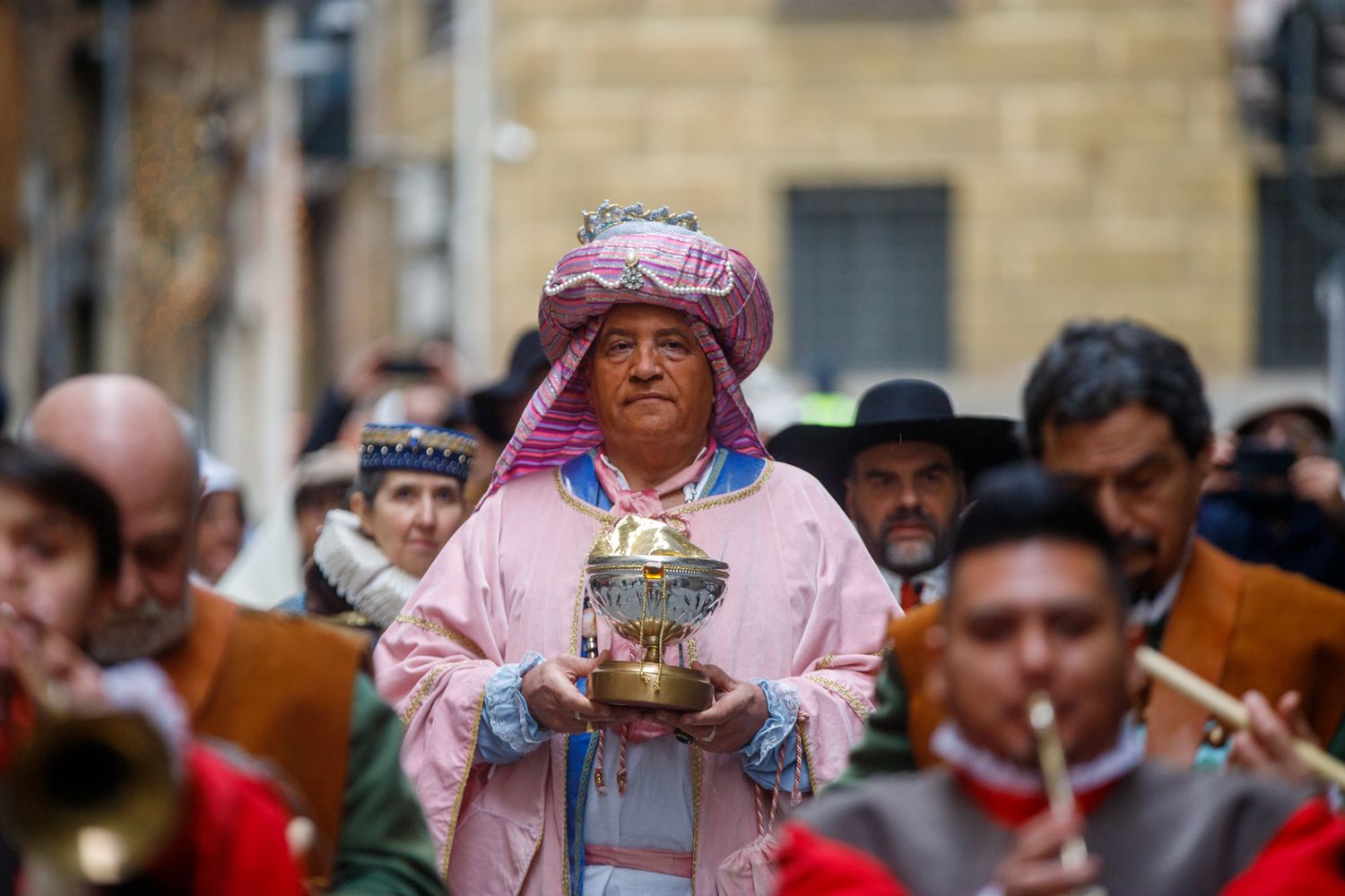 Historical reenactors in period costumes gather at a traditional festival or celebration.