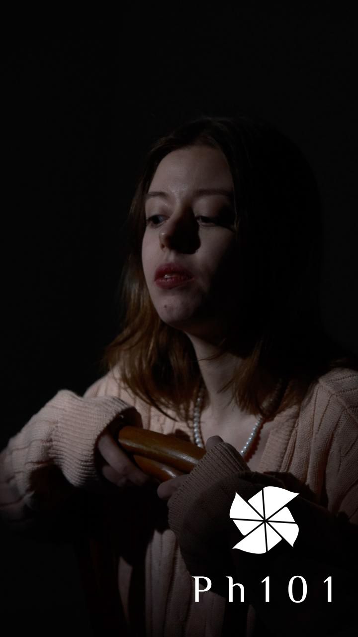 A series of dark moody portraits in low light showing someone wearing a light colored sweater against a black background.
