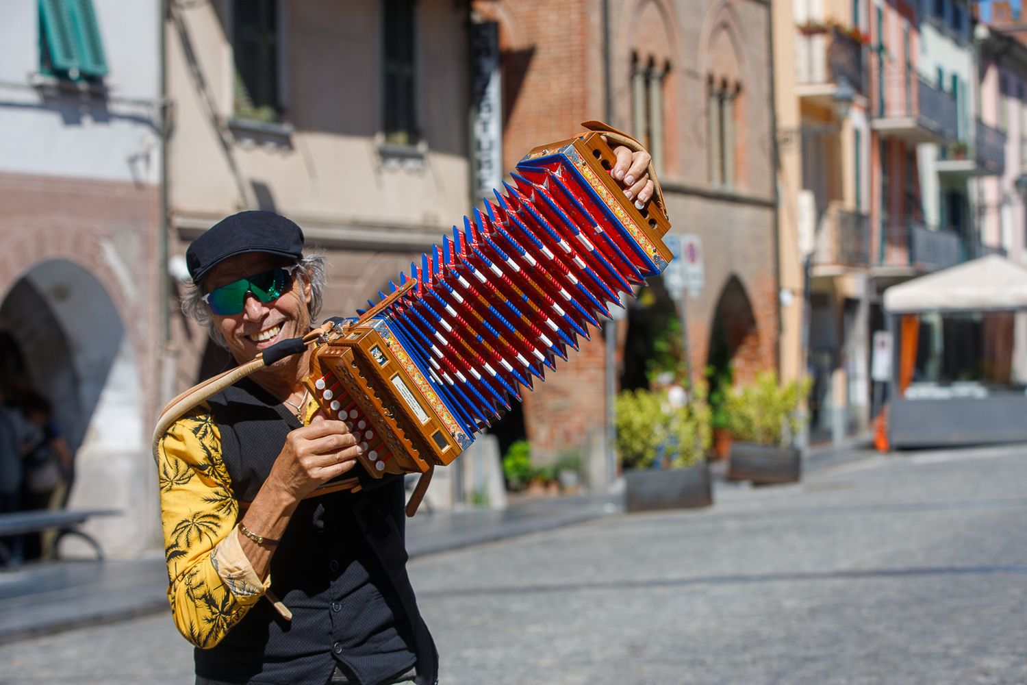Street musician playing accordion on a historic cobblestone street.