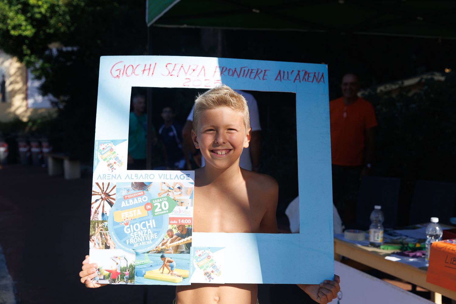 Children participating in outdoor summer camp activities with colorful signs and decorations.