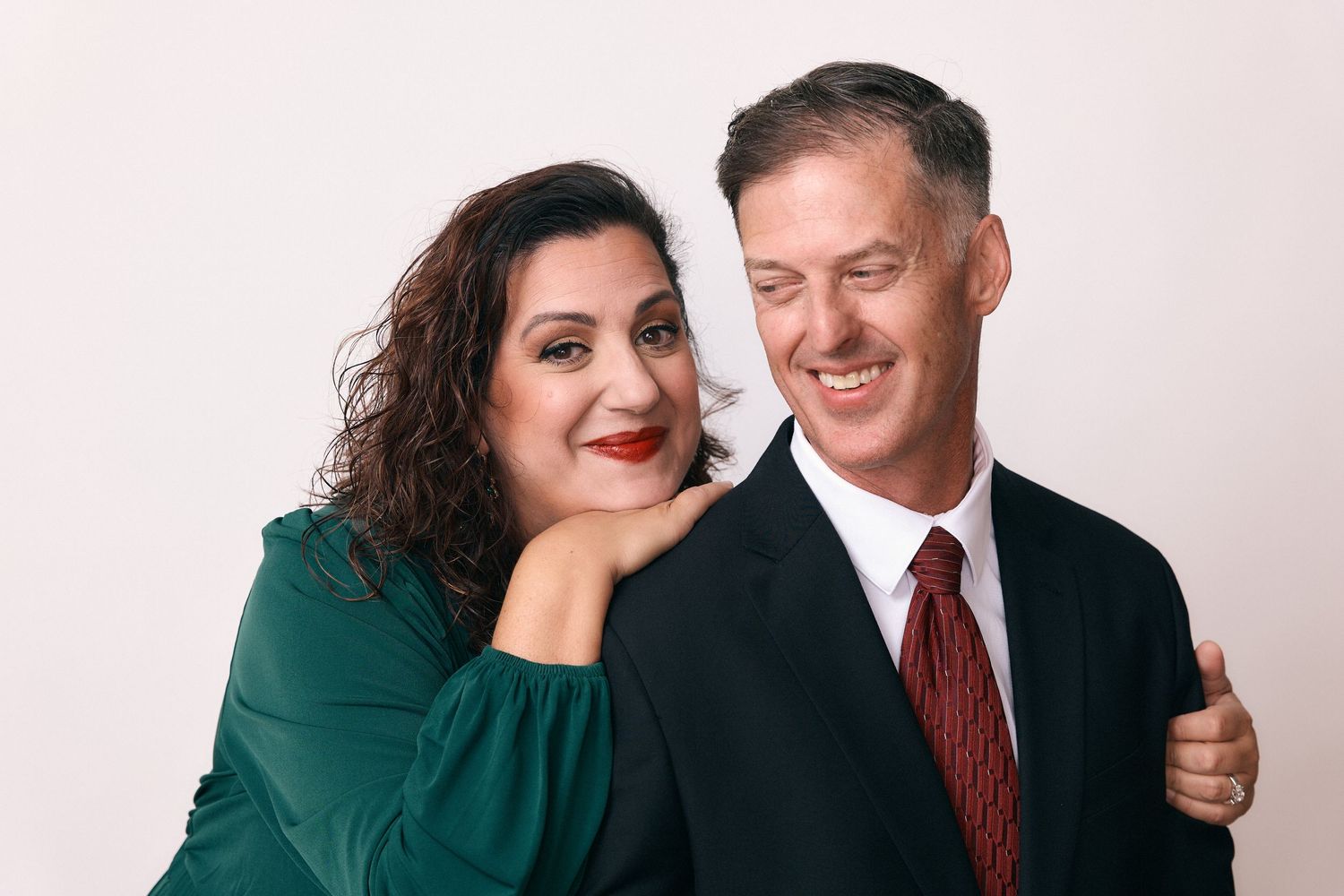 Couple in formal wear sharing intimate moments and laughter in studio portraits.