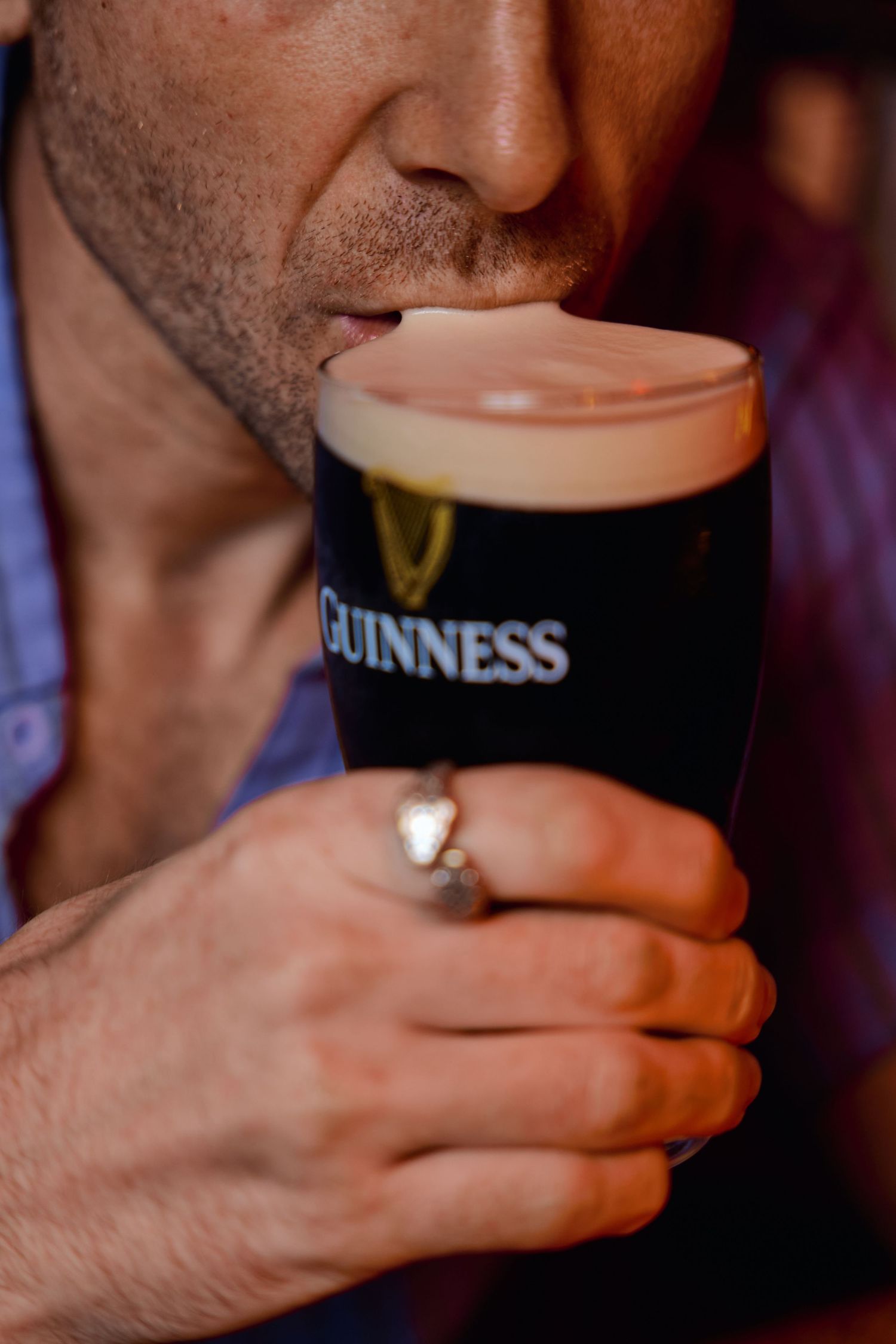 Close-up shots of someone drinking a pint of Guinness beer showing the creamy foam head.