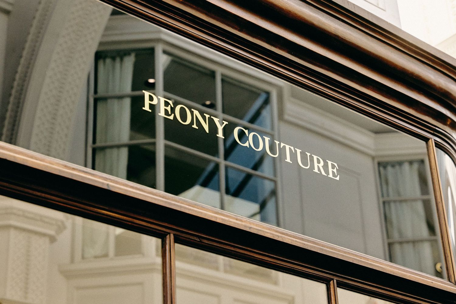Elegant storefront window display featuring 'Peony Couture' signage and luxurious retail branding.