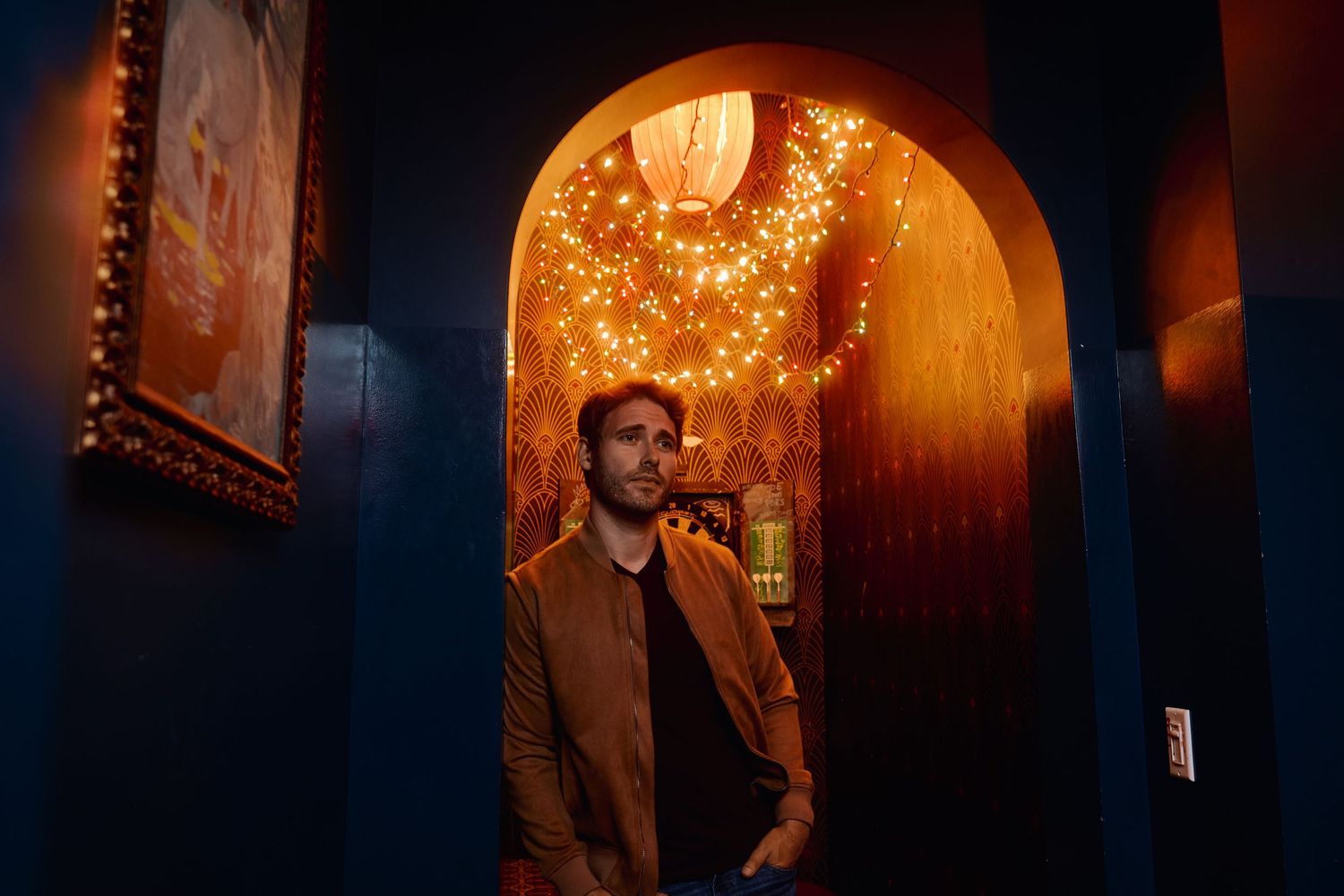 Atmospheric portraits in a dimly lit space with warm glowing archways.
