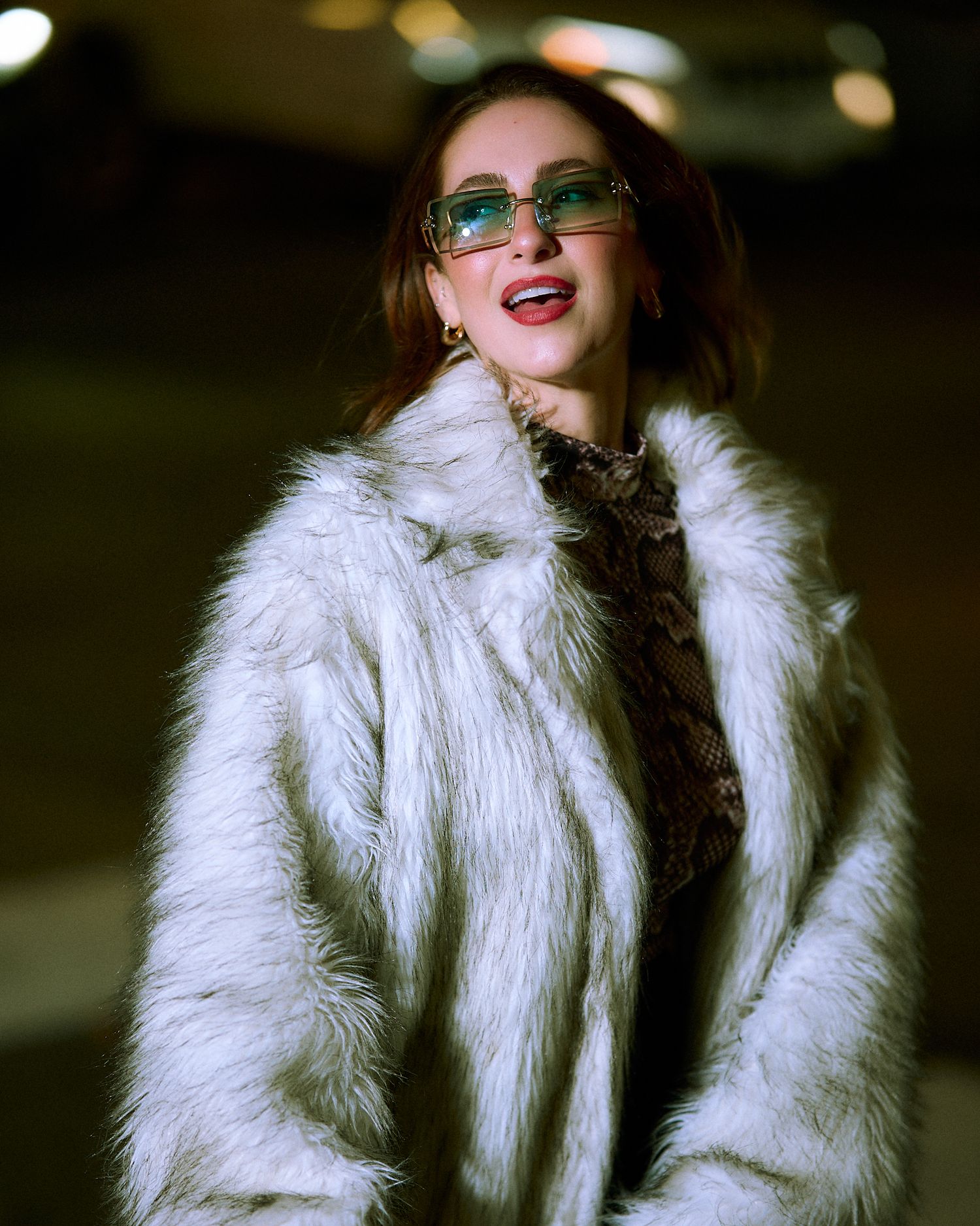 Stylish white faux fur coat captured in moody lighting.
