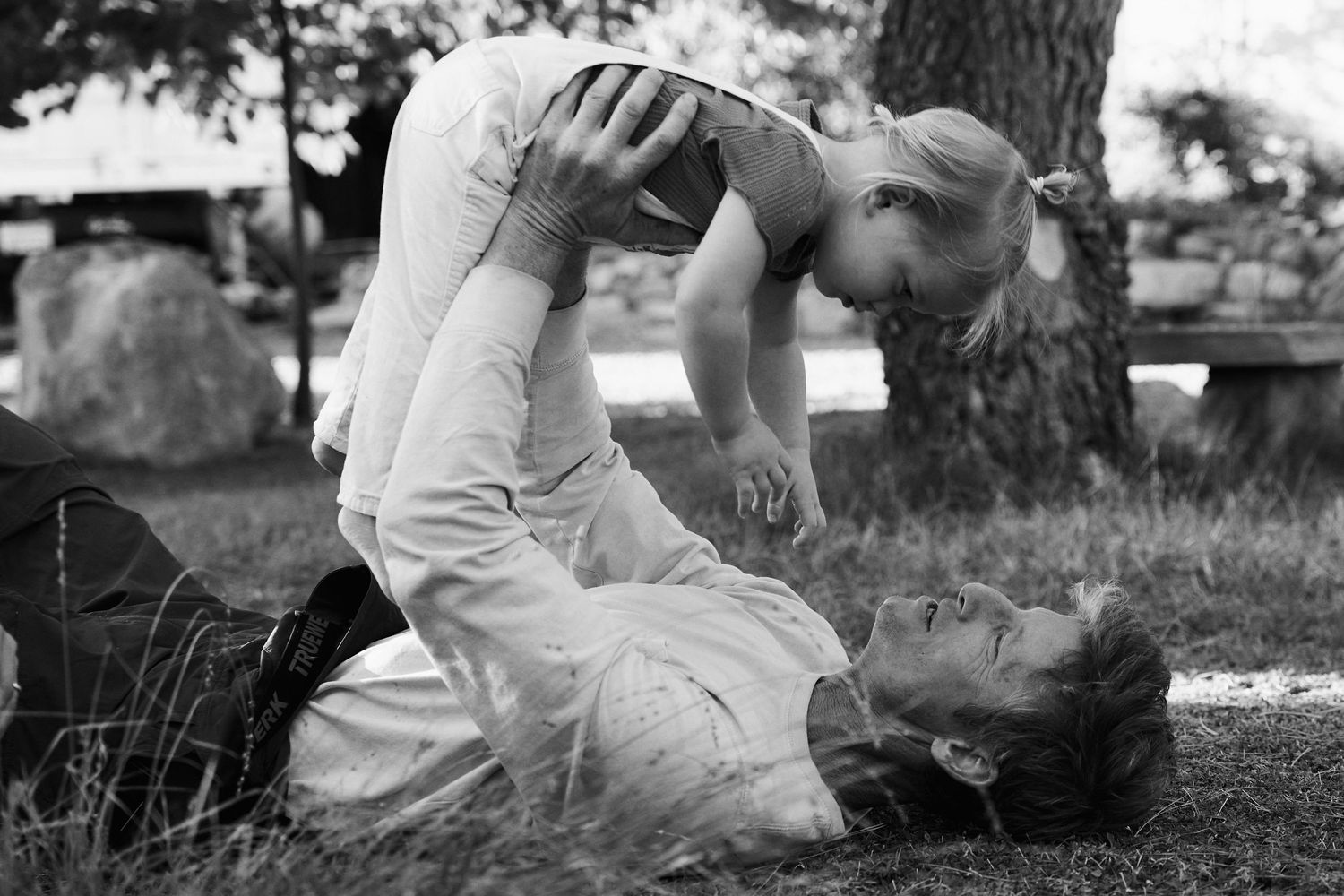 Black and white outdoor photo session on grassy ground.