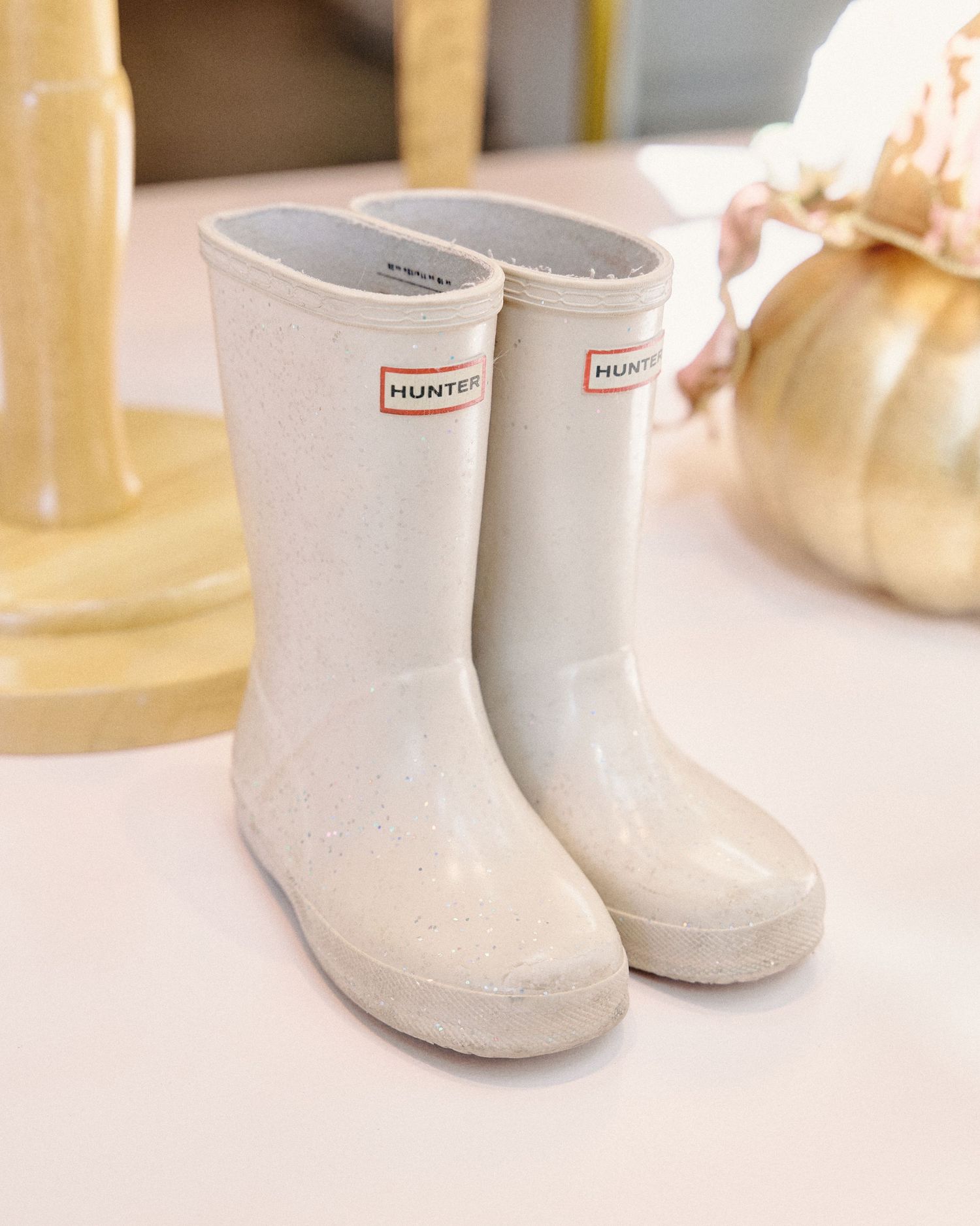 White Hunter rain boots arranged in a row on a clean white surface with natural lighting.