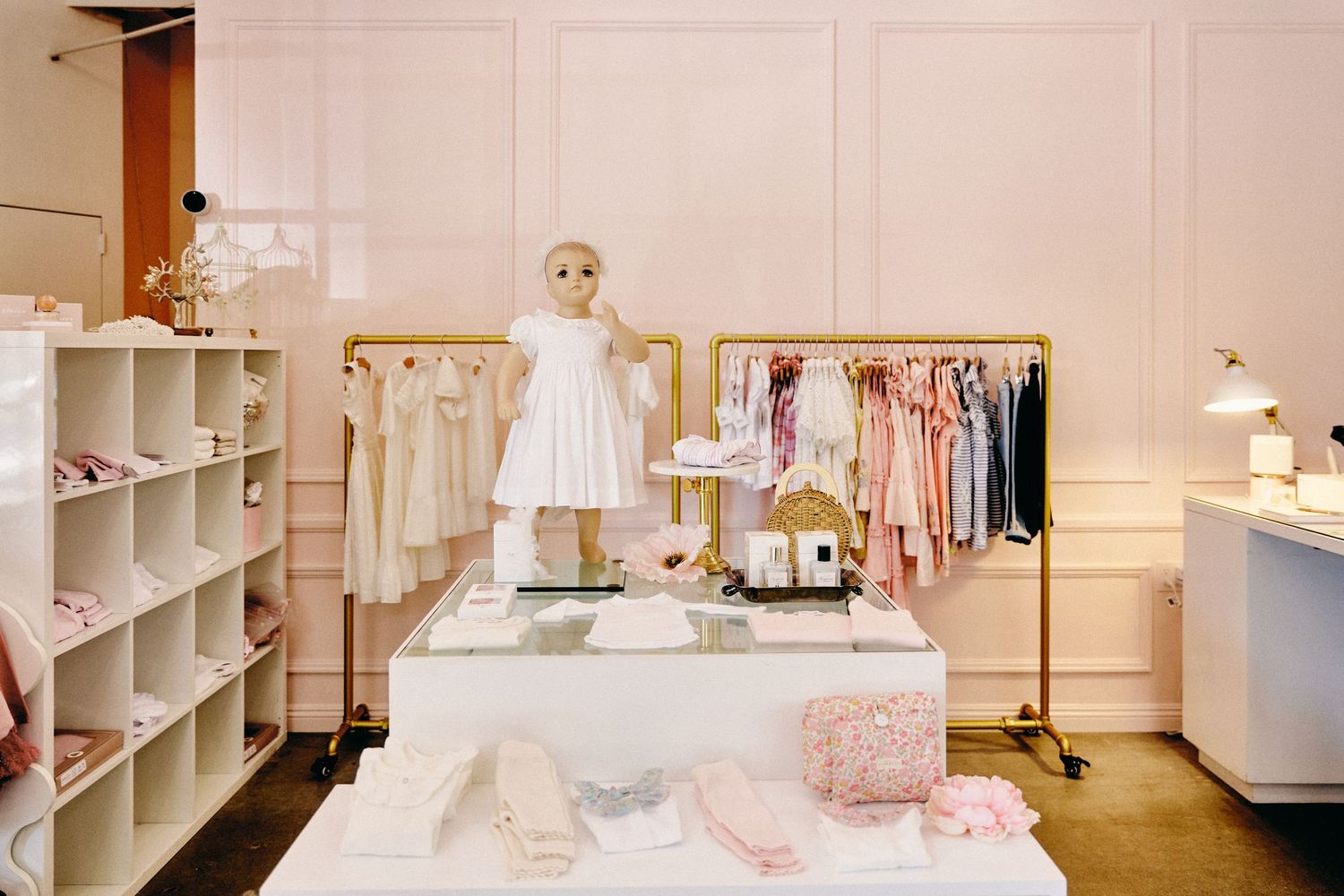 A series of white built-in shelves and cabinets in a bright, modern retail store interior.