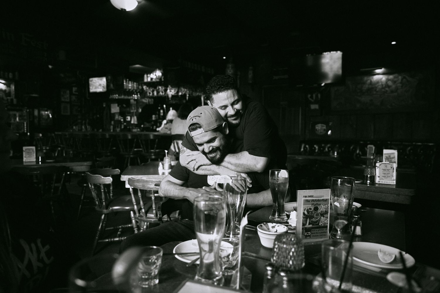Dark interior of a bar with patrons sitting at tables.