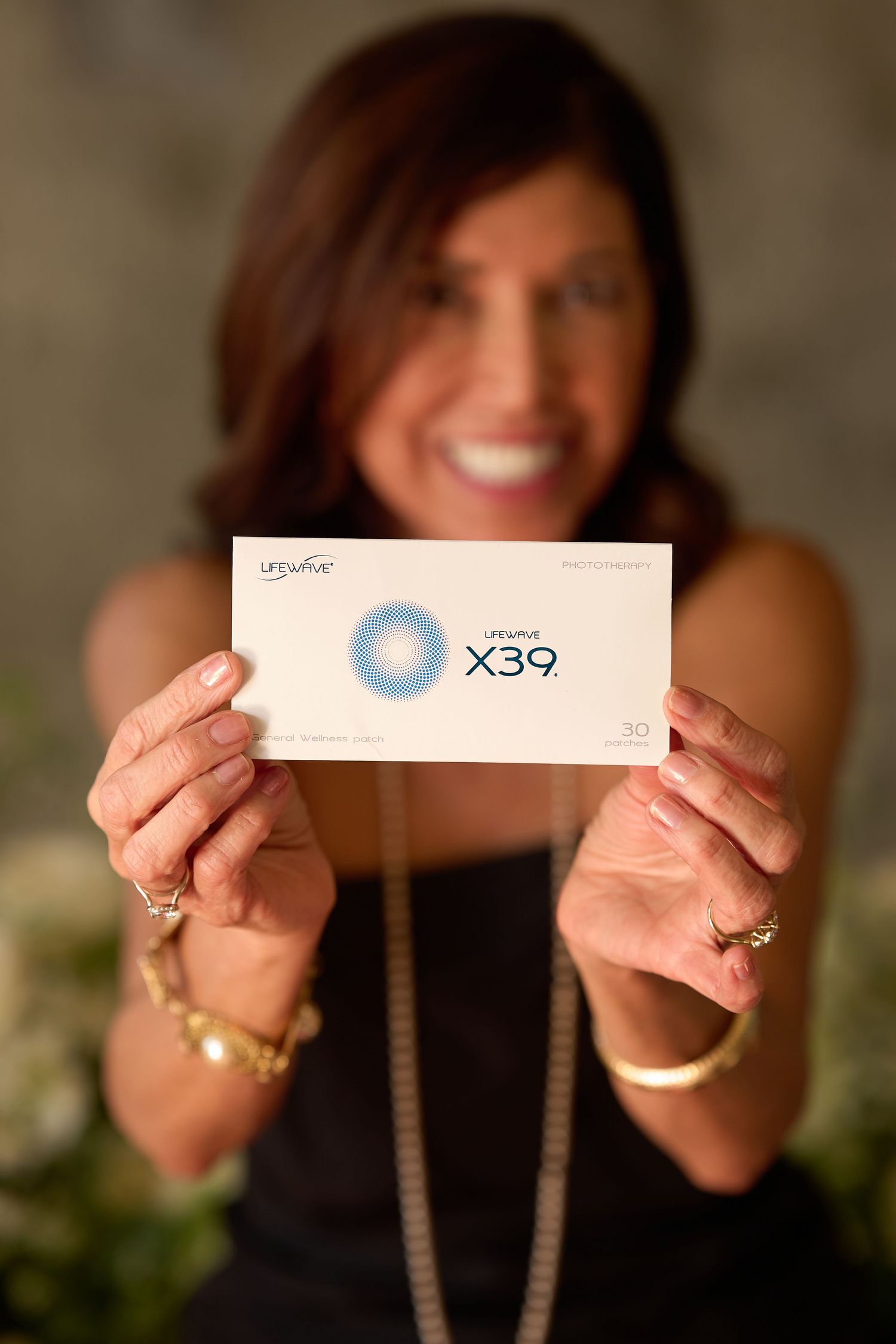 Someone holds up a white card or ticket marked with X39 while wearing gold jewelry and a dark top.