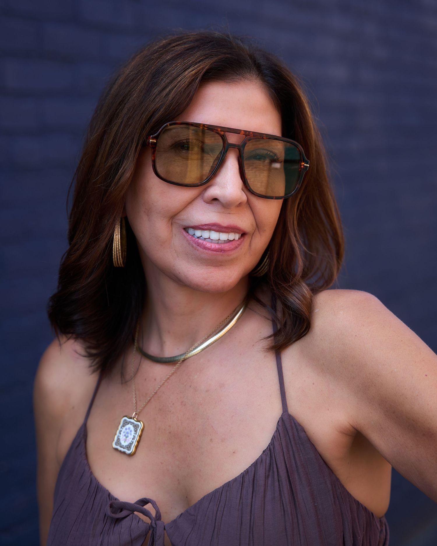 Portrait series in brown dress showing various poses against dark blue background.