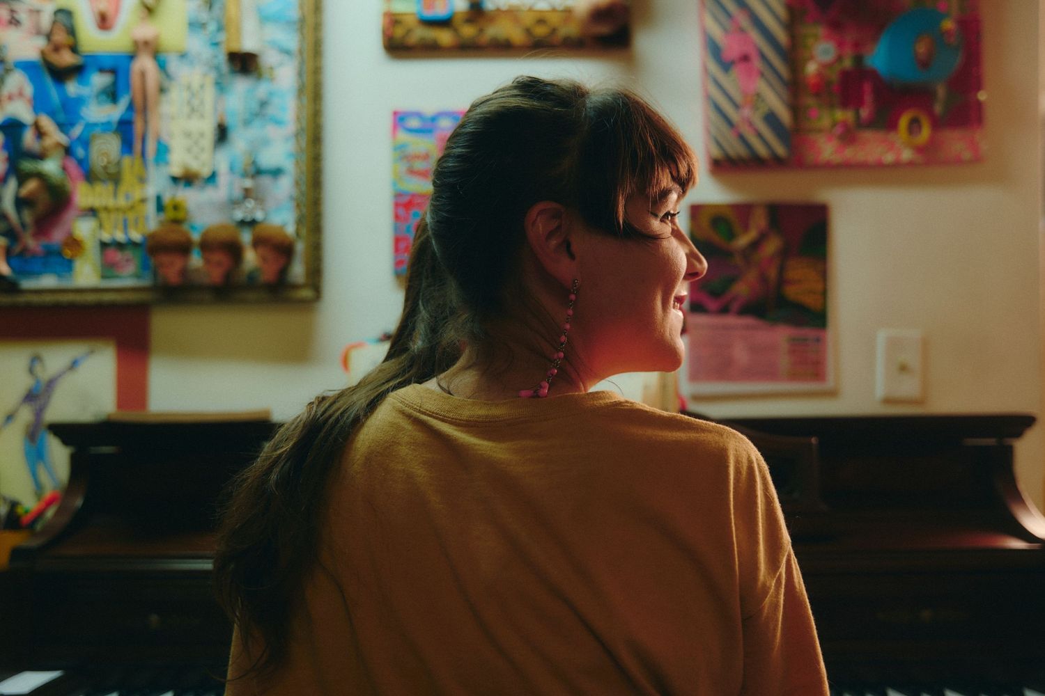 Interior scene with colorful artwork displayed on walls in warm lighting.
