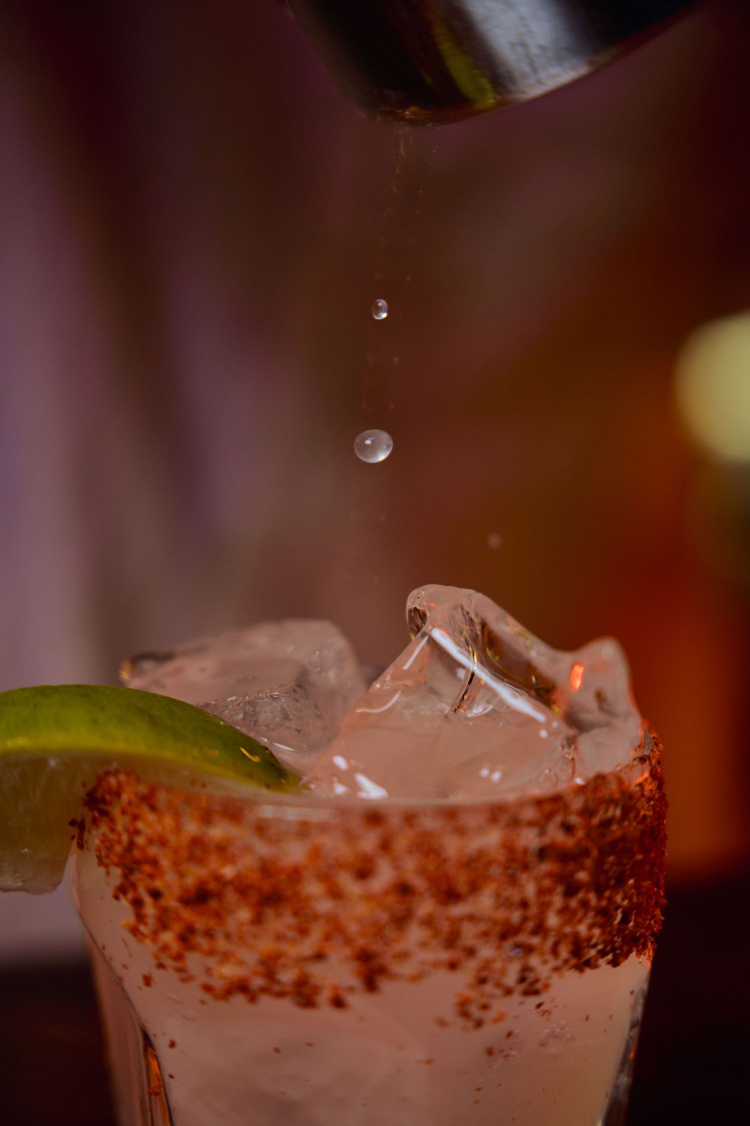 Close-up shots of a cocktail glass rim with sugar or salt crystals and lime garnish.
