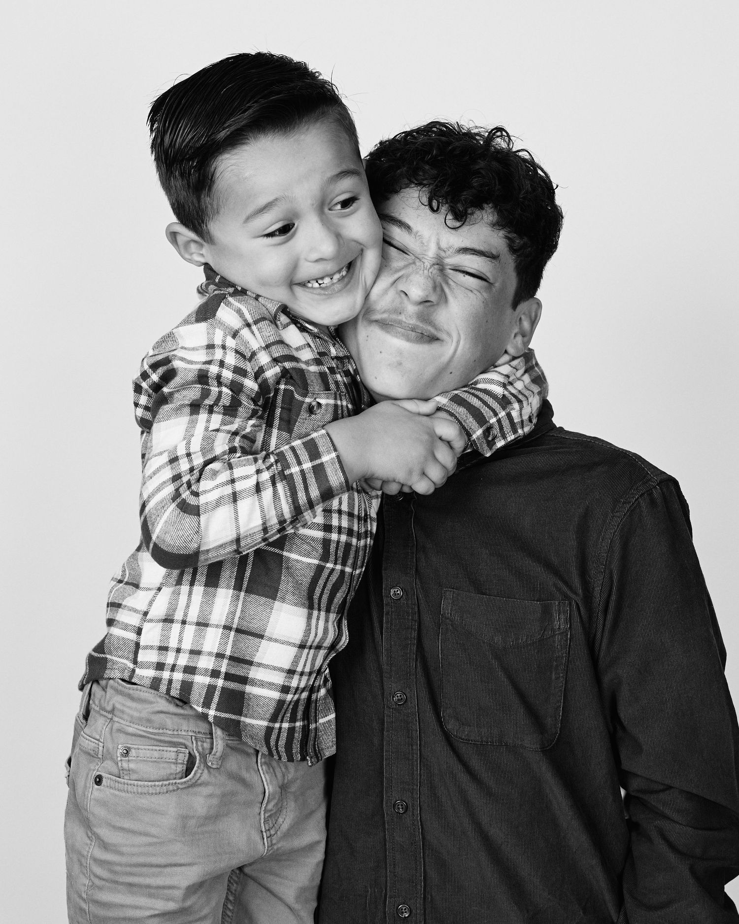 Black and white portraits showing tender moments between parent and child in plaid.