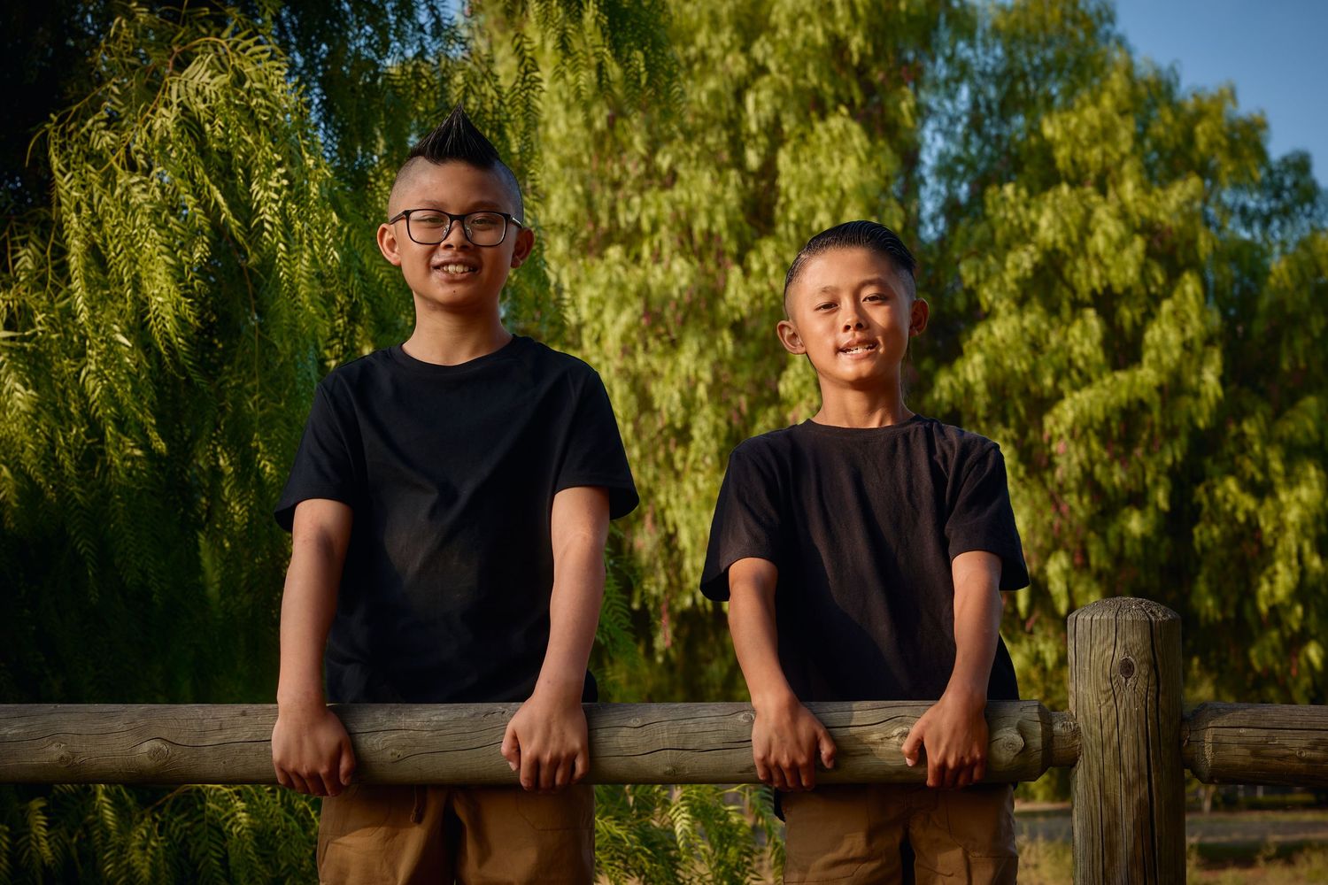 Family portraits taken outdoors with willow trees in the background.