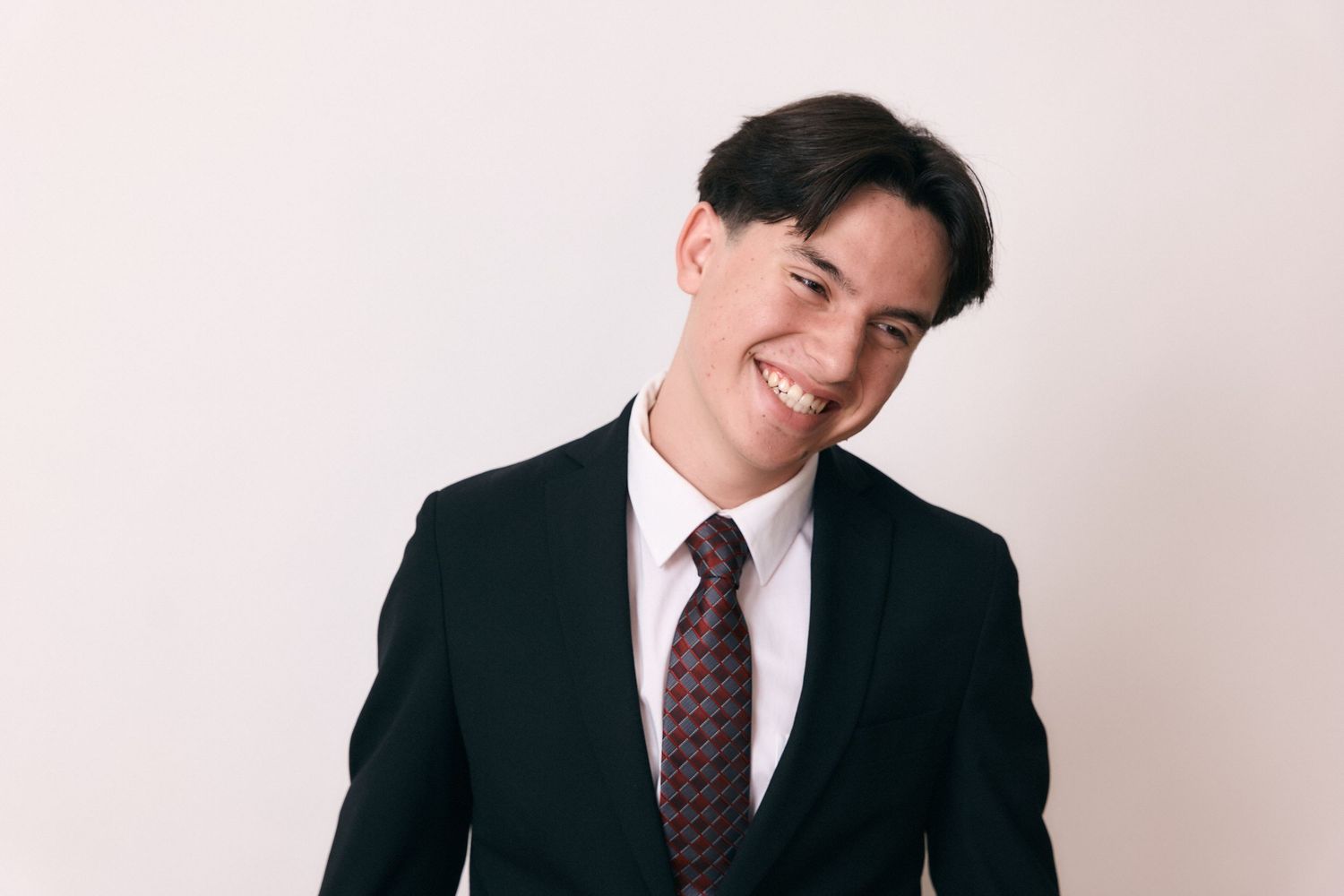 Professional headshots showing someone in business attire with varying expressions.