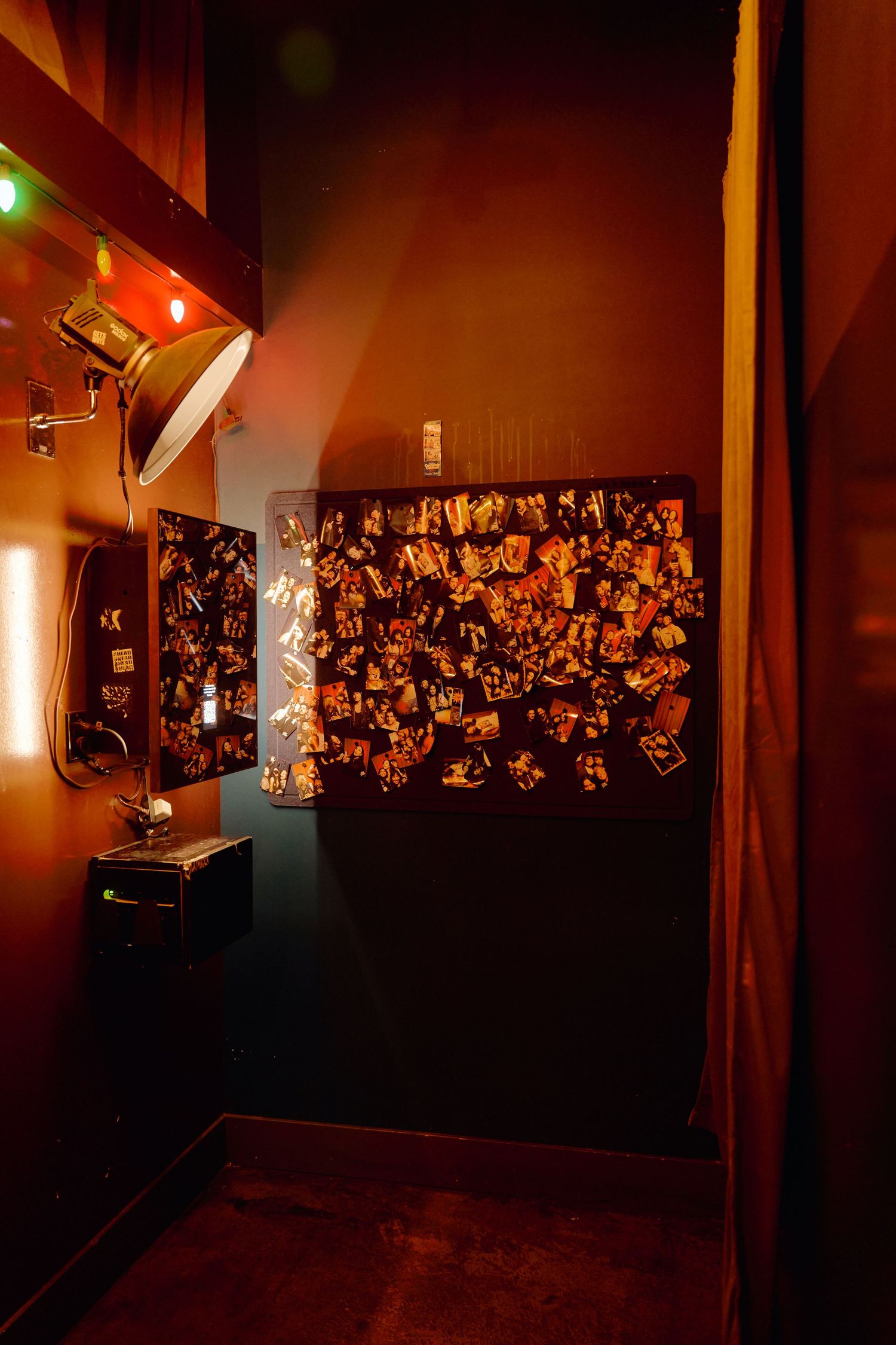 Dark hallway with red ambient lighting and wall decorated with illuminated hanging ornaments.