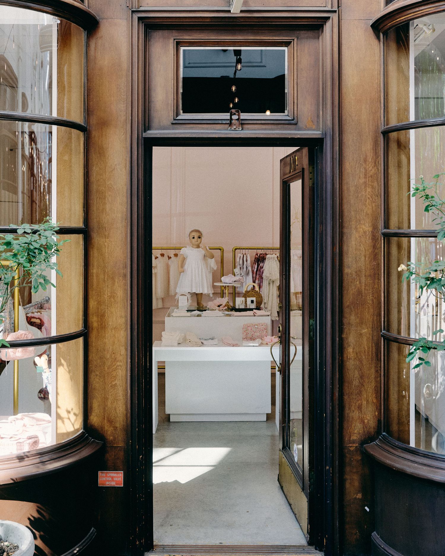 Multiple wooden framed glass display cases line the walls of an elegant retail interior space.