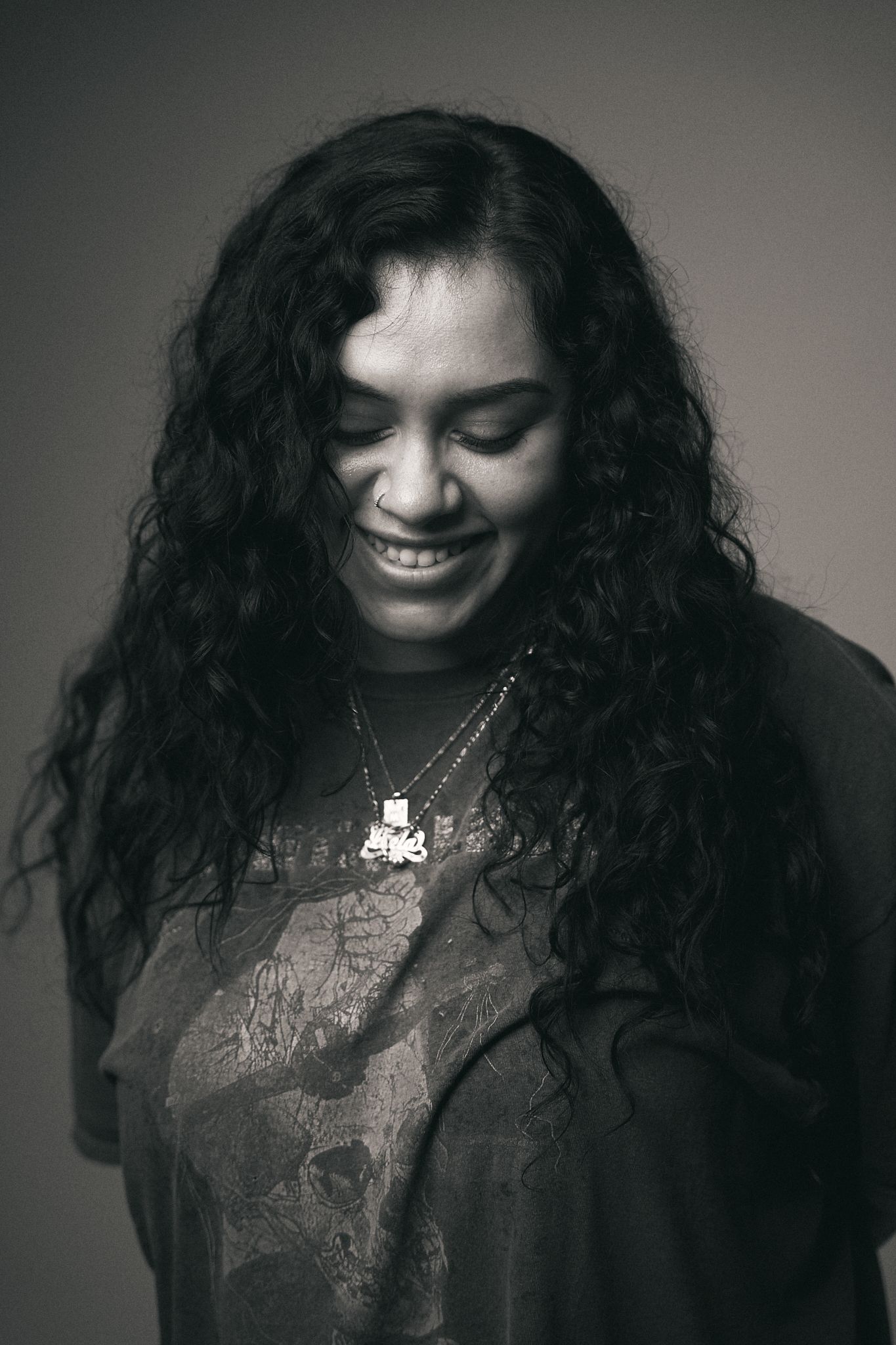 Black and white portraits of someone with curly dark hair showing different moods and expressions.