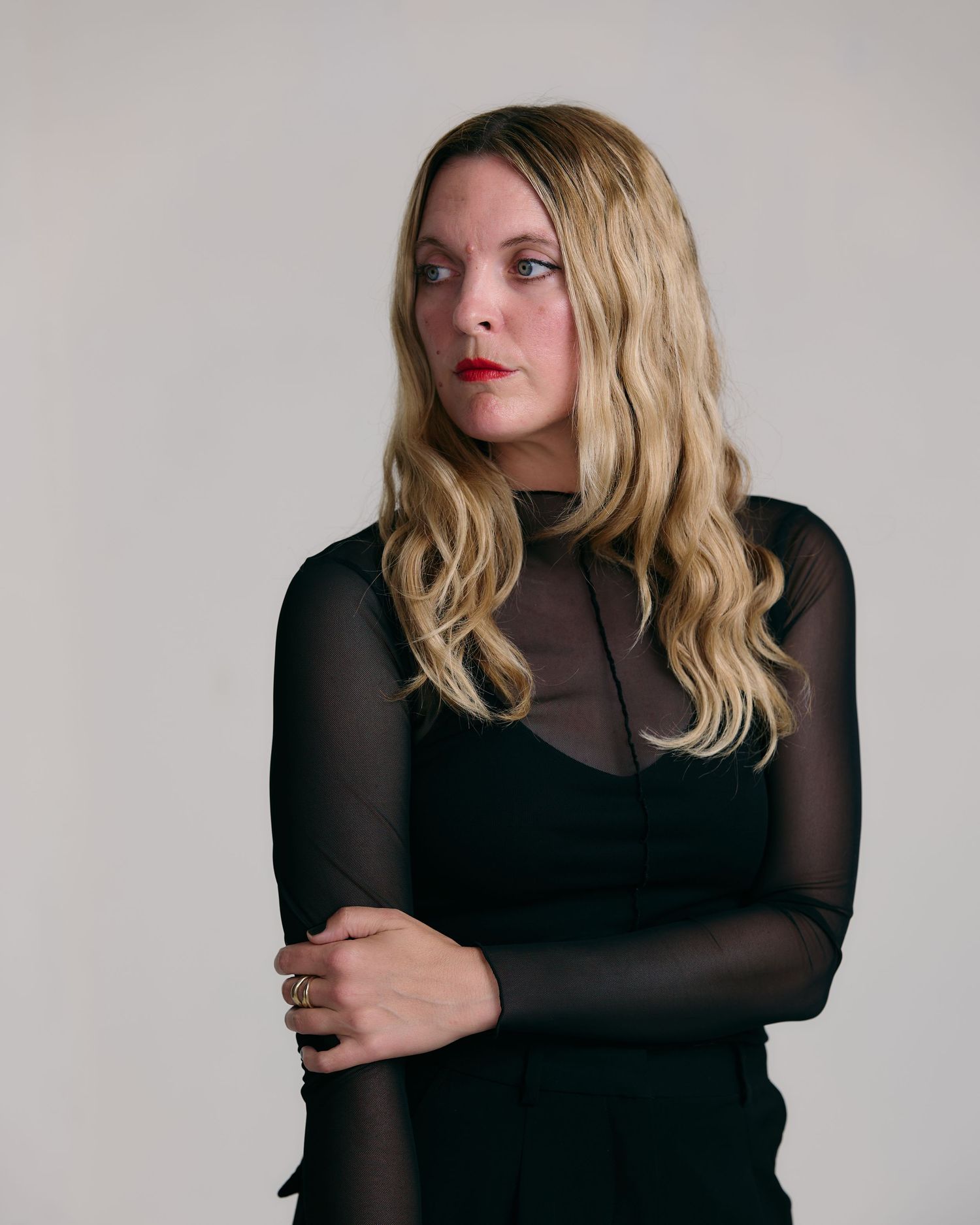 Artistic black and white portrait series featuring blonde hair and sheer black clothing against neutral background.